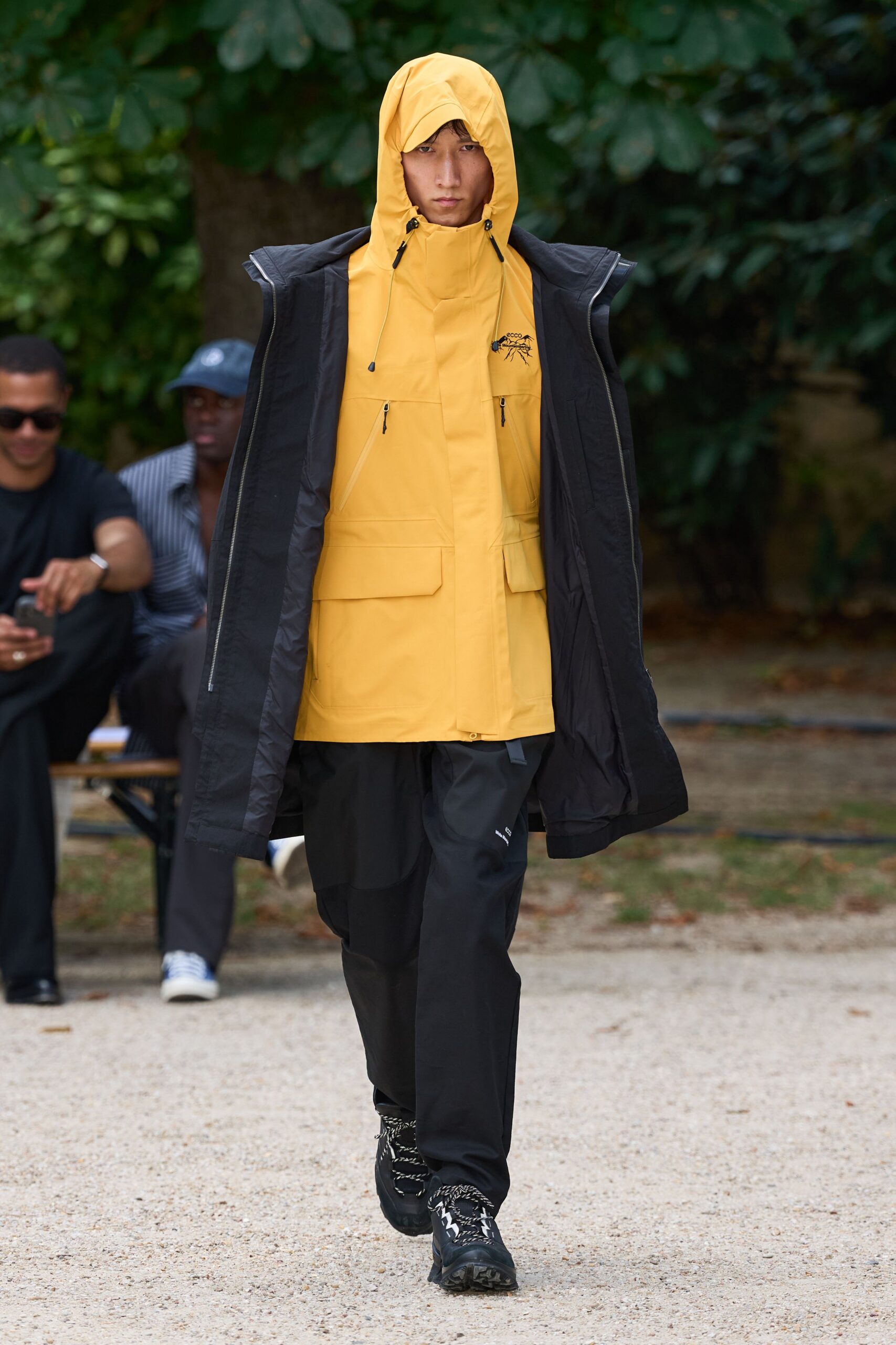 yellow hooded jacket with black pants