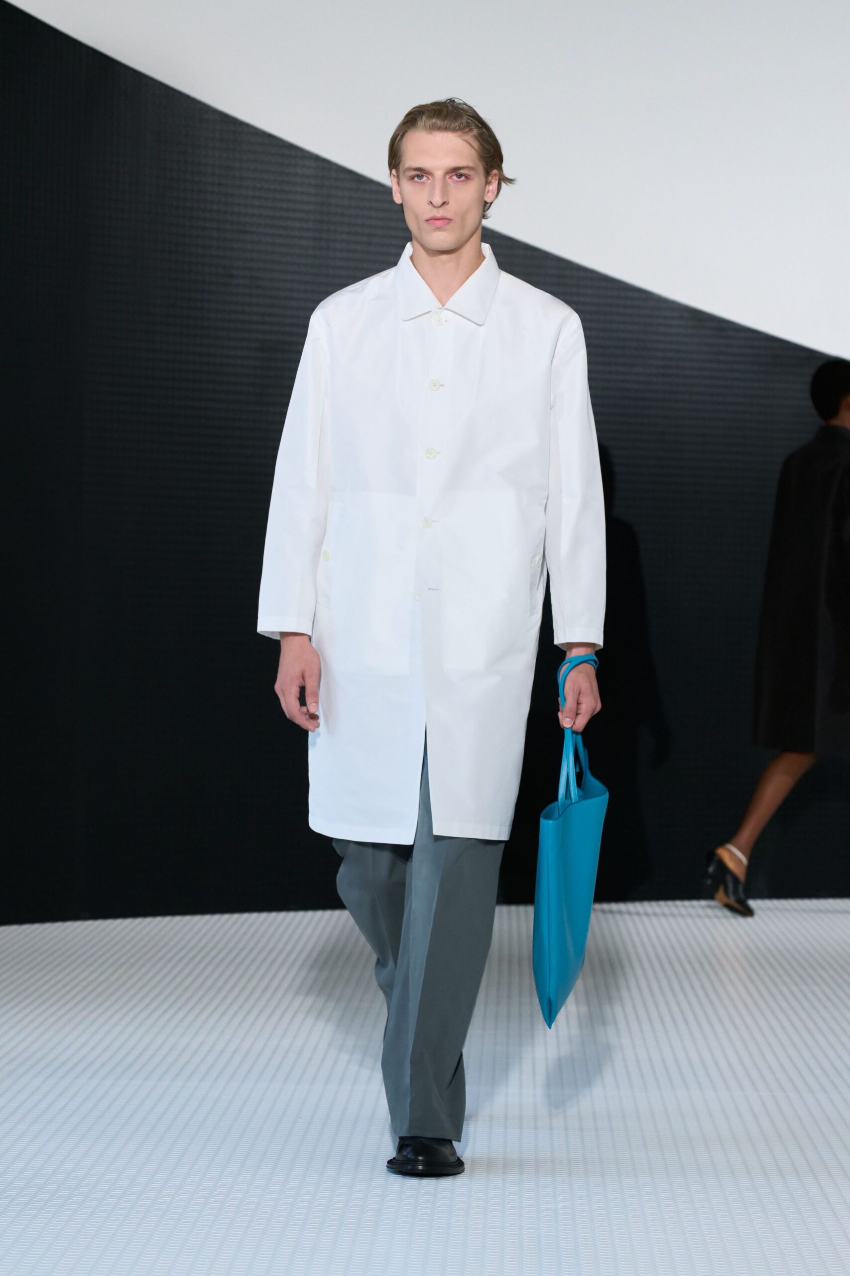 white coat gray pants black shoes blue bag