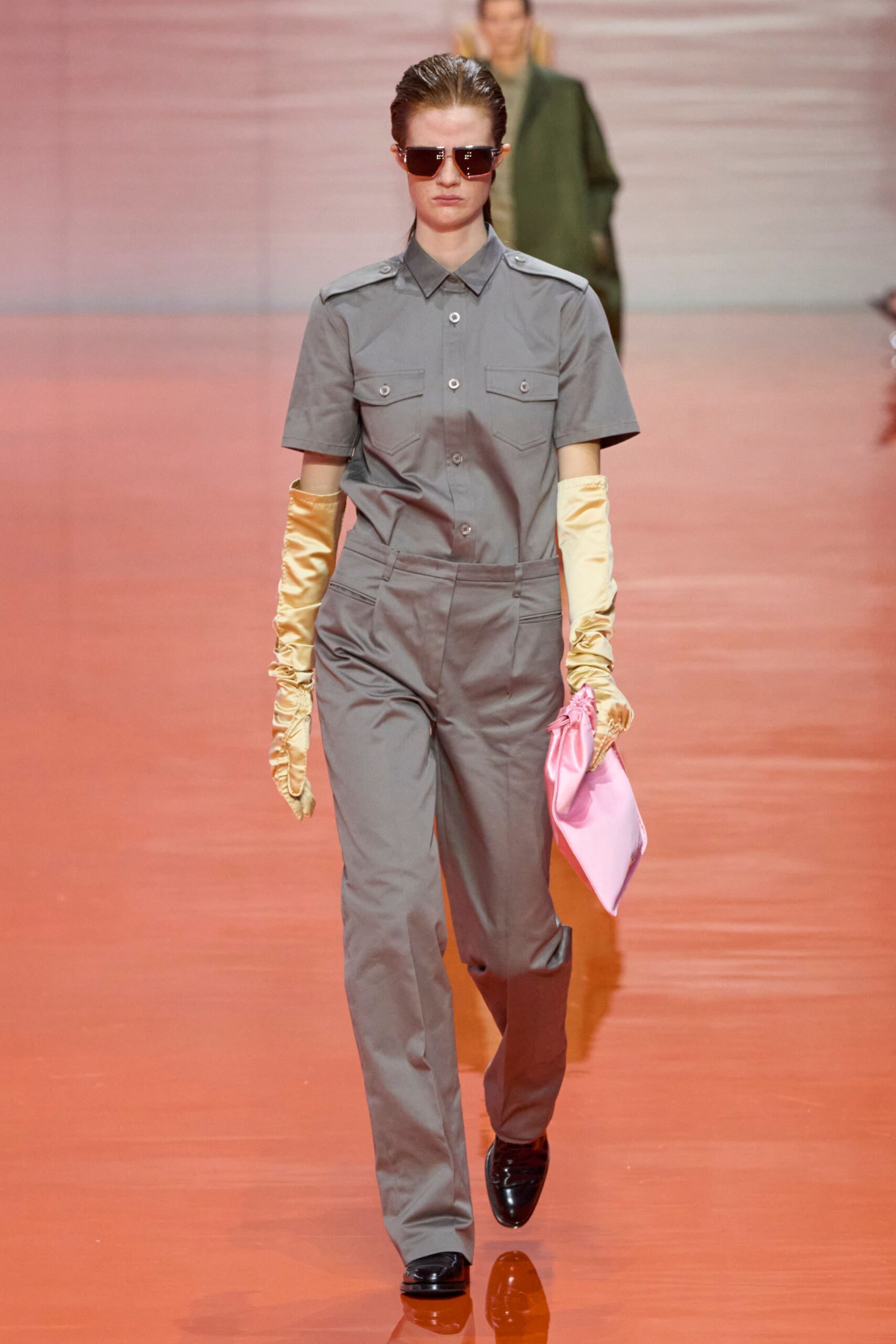 gray fitted jumpsuit with gold gloves