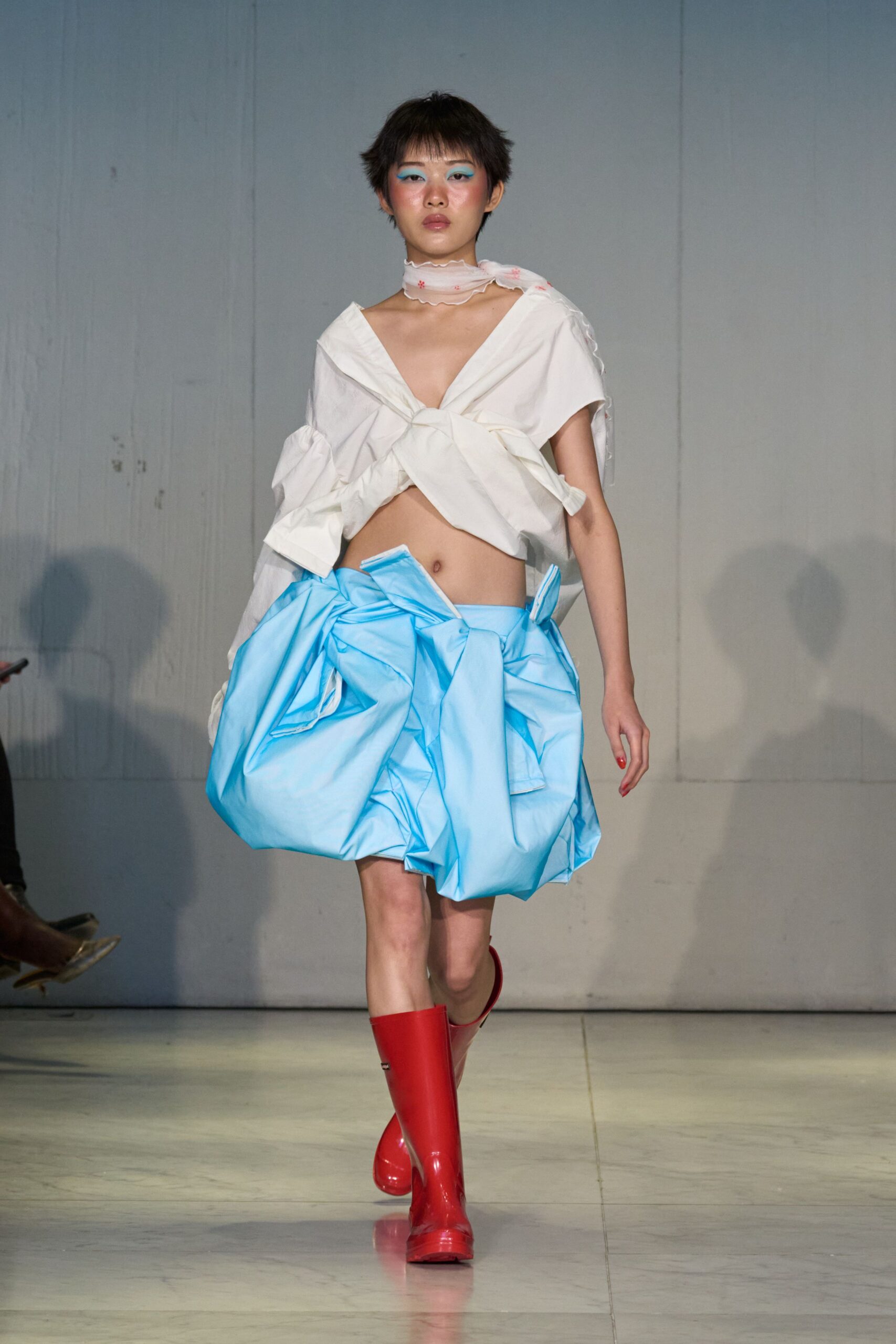 white top blue pleated skirt red boots