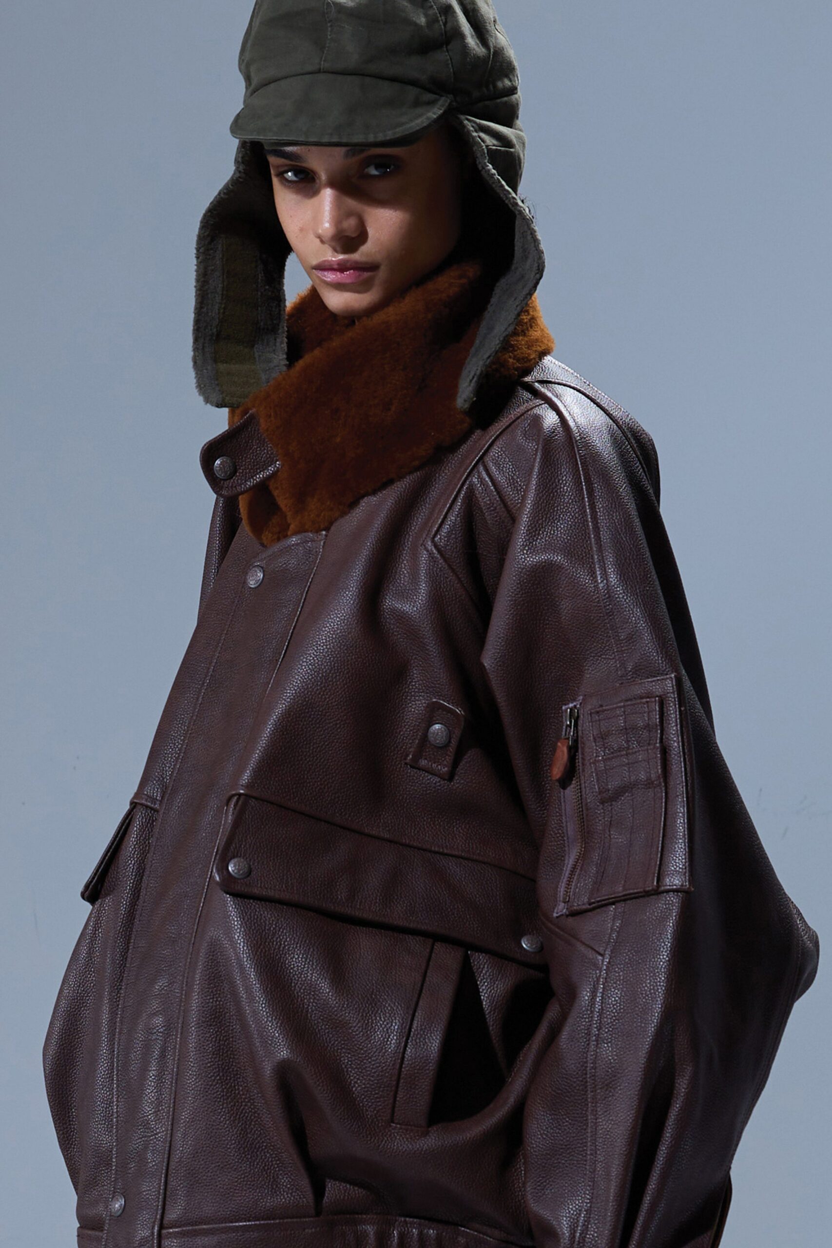 oversized brown leather jacket with green hat