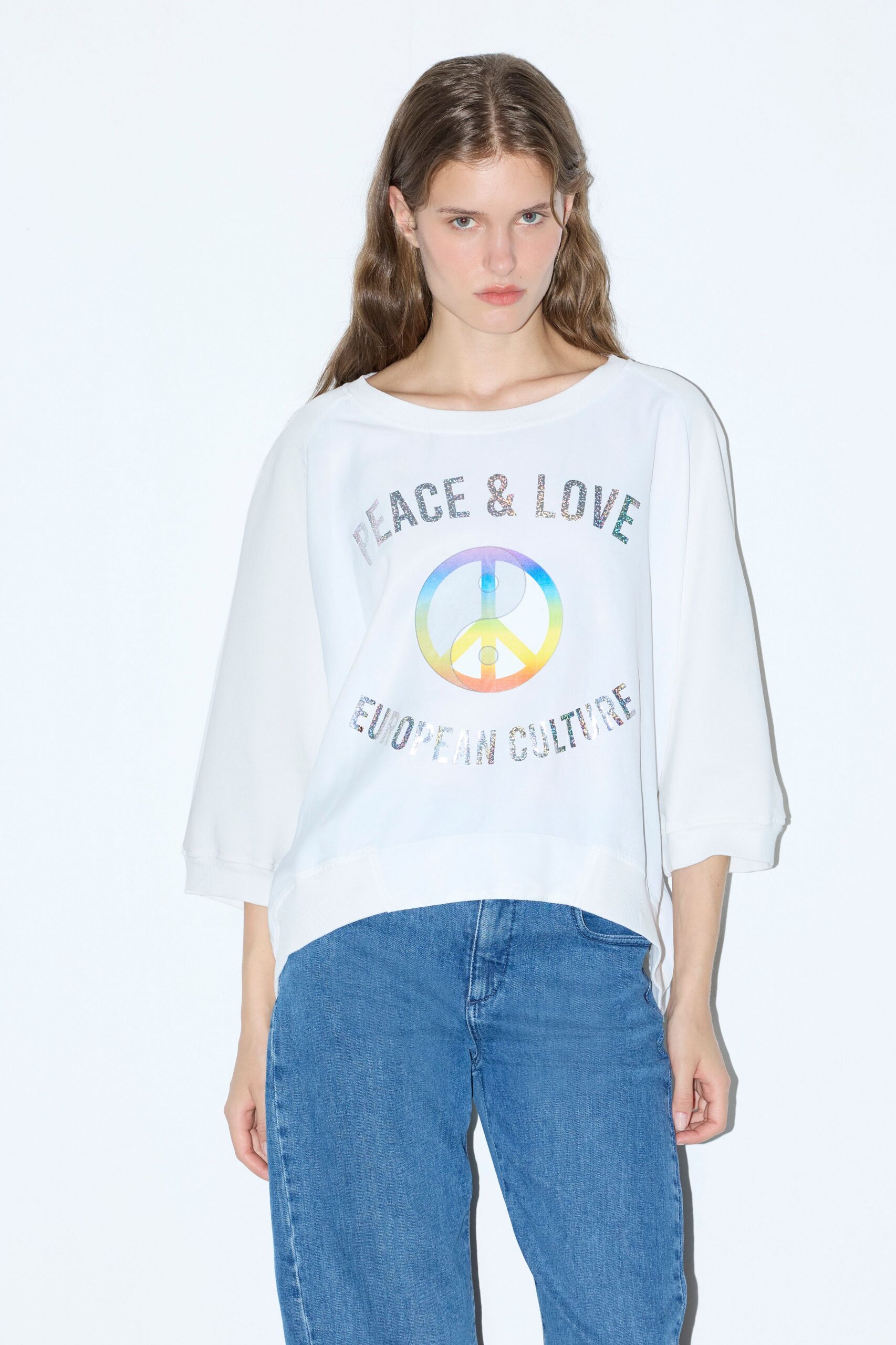 white relaxed top with printed design and blue jeans