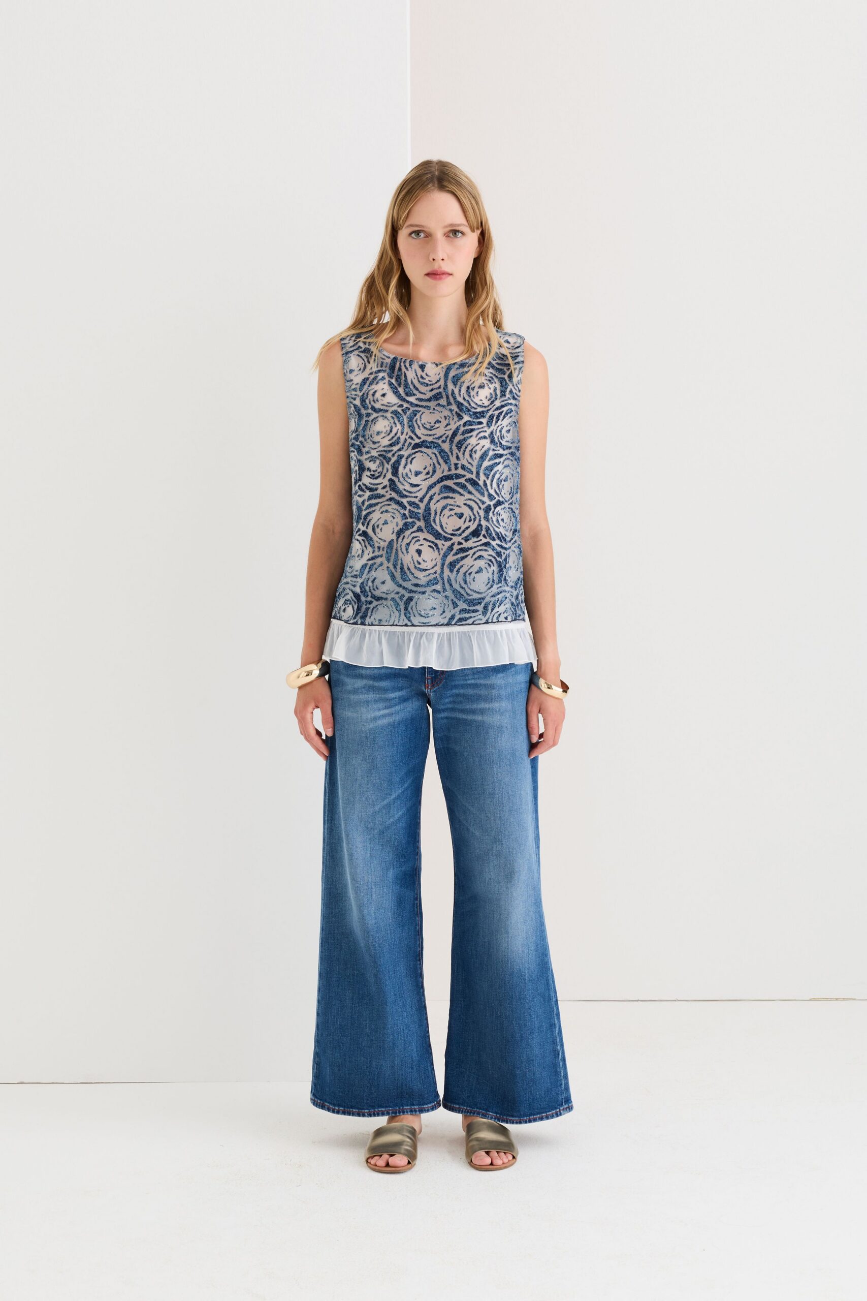blue embroidered sleeveless top with wide-leg jeans