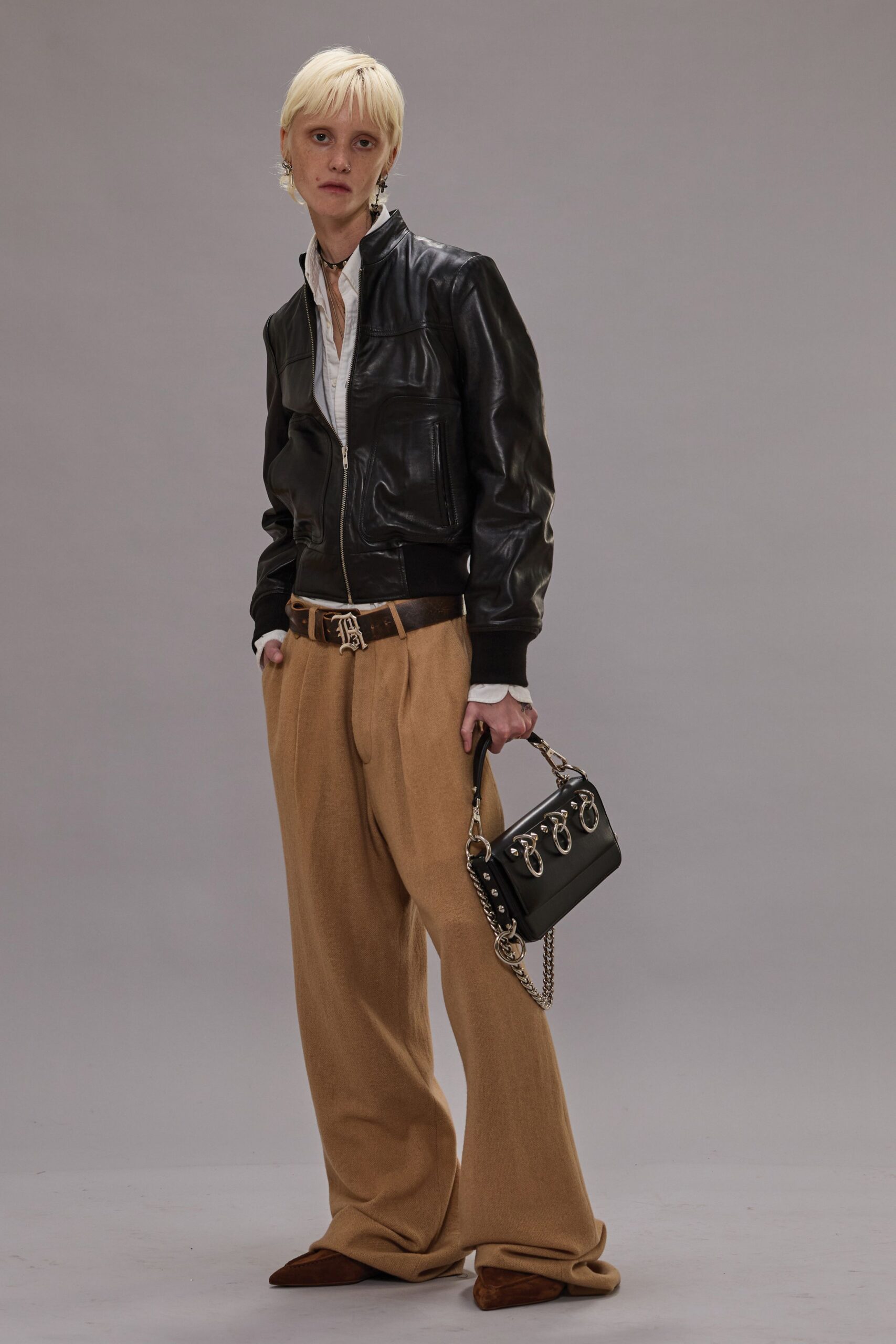 black leather jacket with beige pants