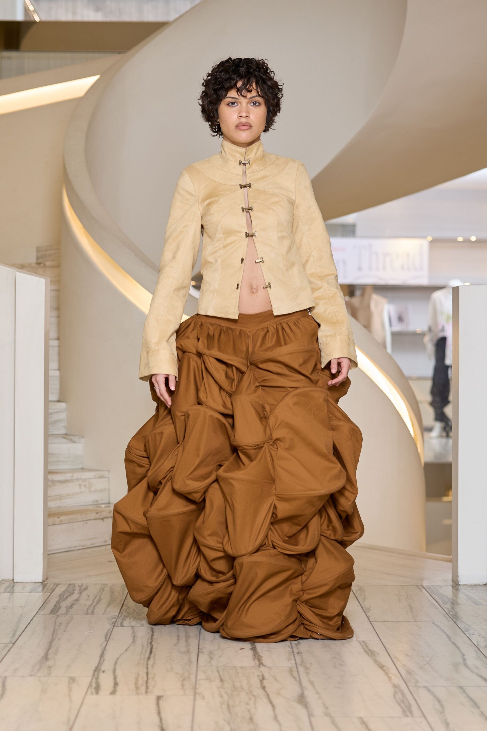 beige fitted jacket and brown pleated skirt