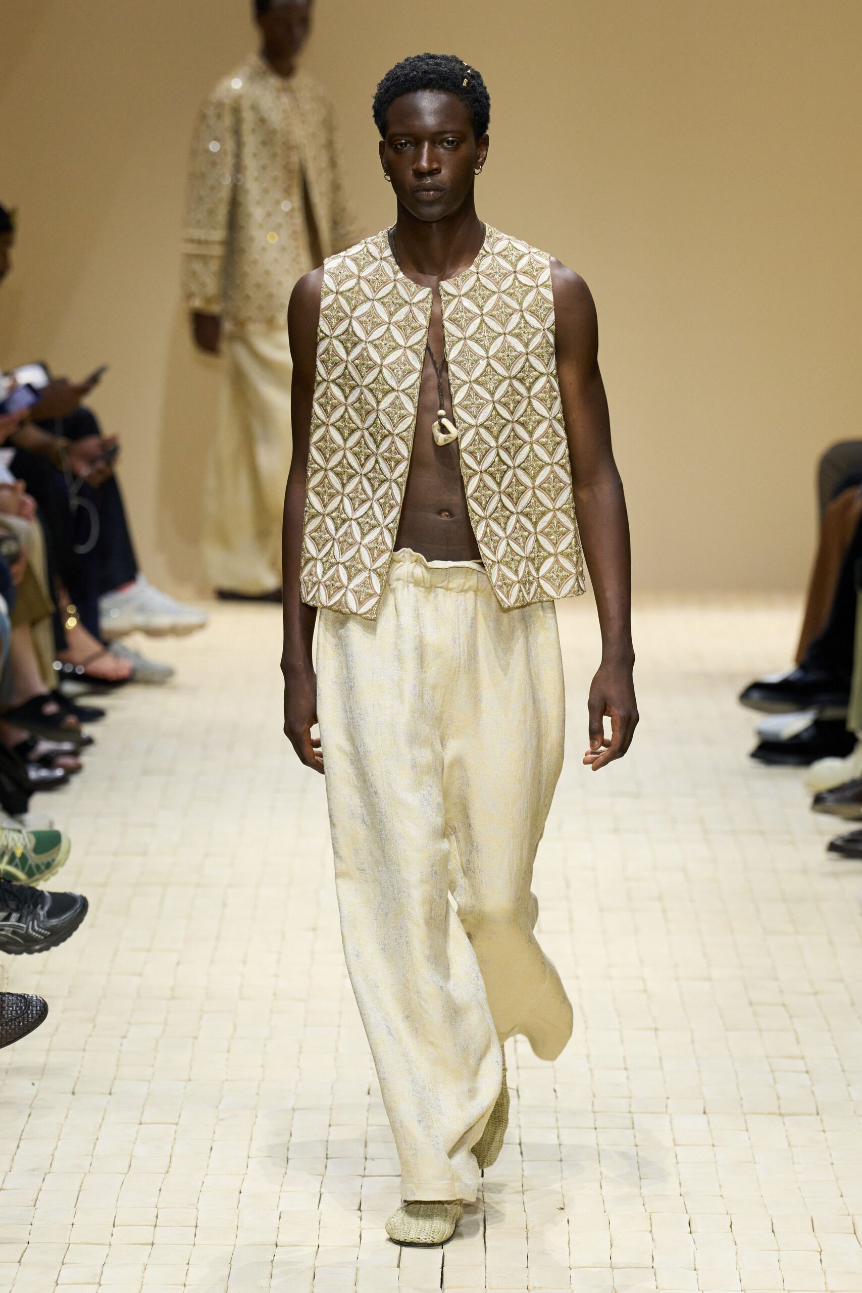 gold embroidered vest with beige pants
