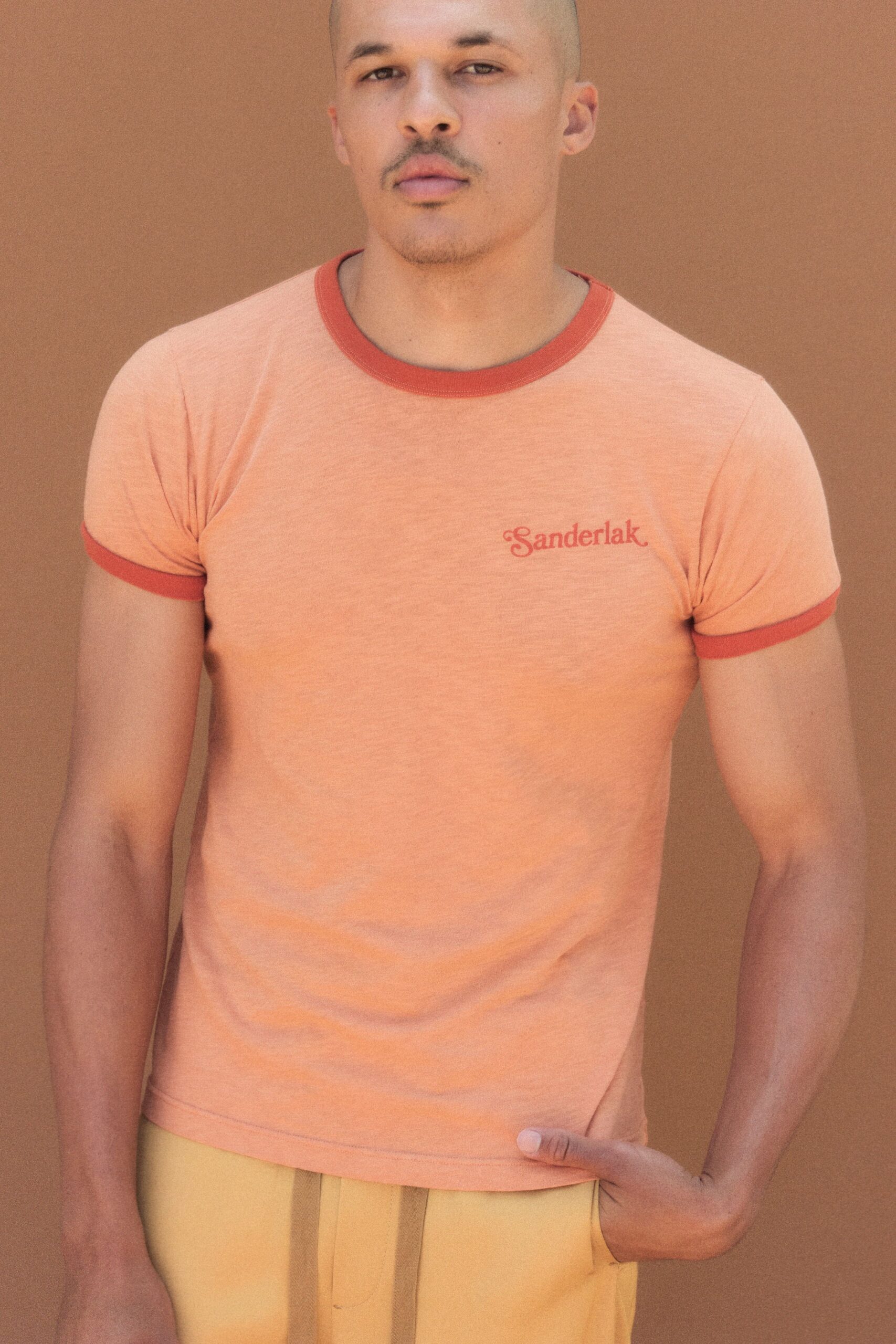 orange fitted t-shirt and beige pants