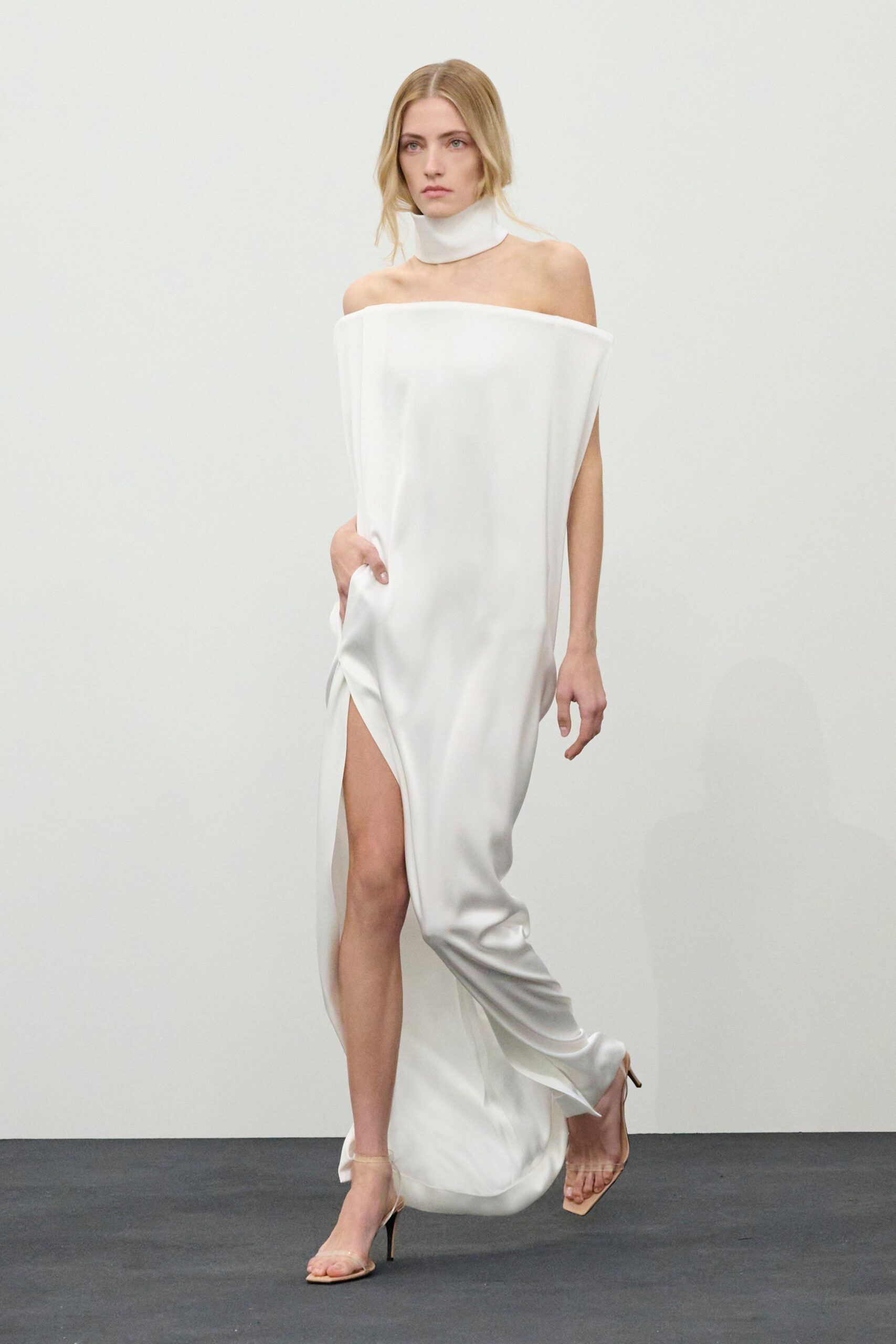 white silk sleeveless off-shoulder fitted draped flowing gown
