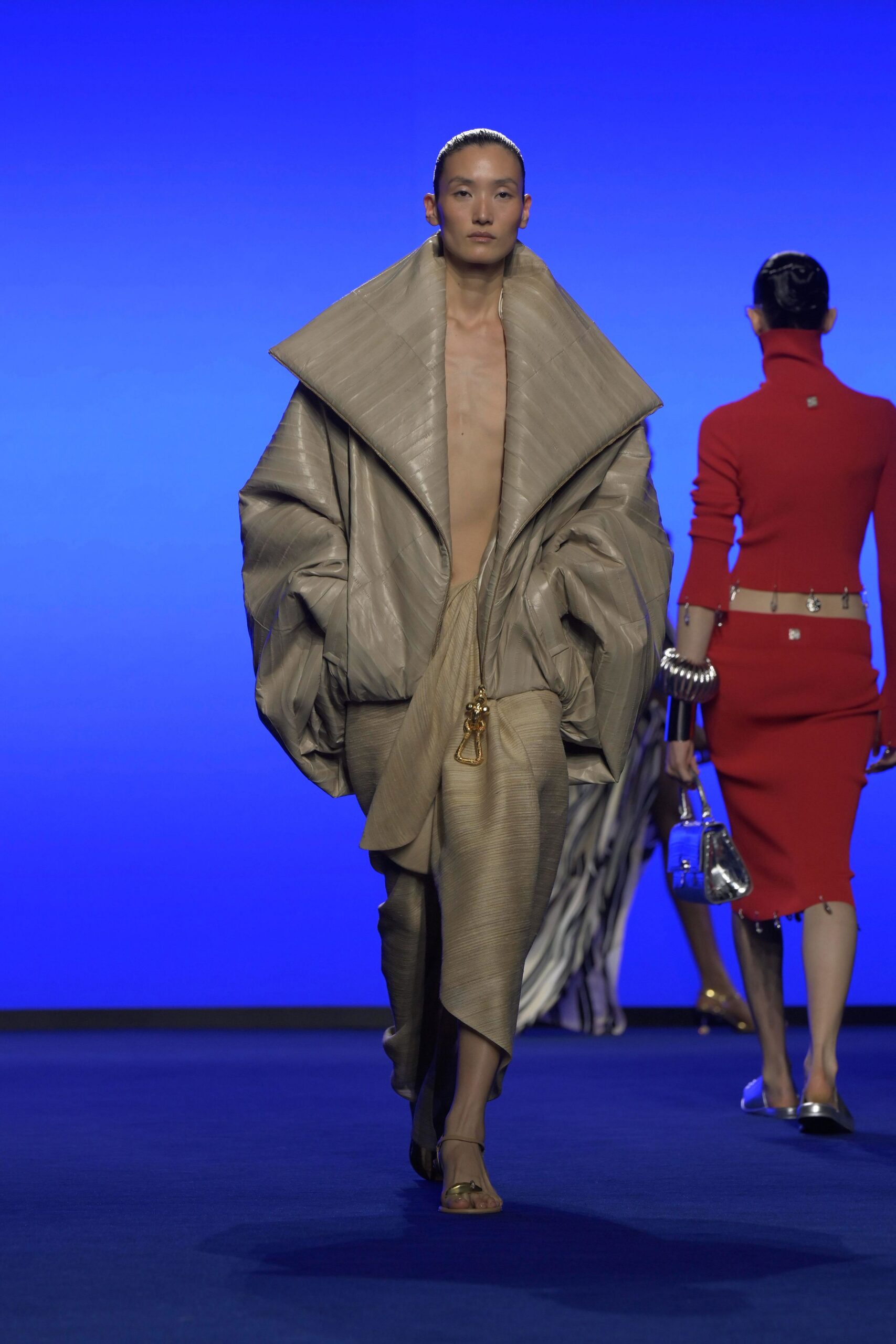 beige oversized coat and red fitted dress