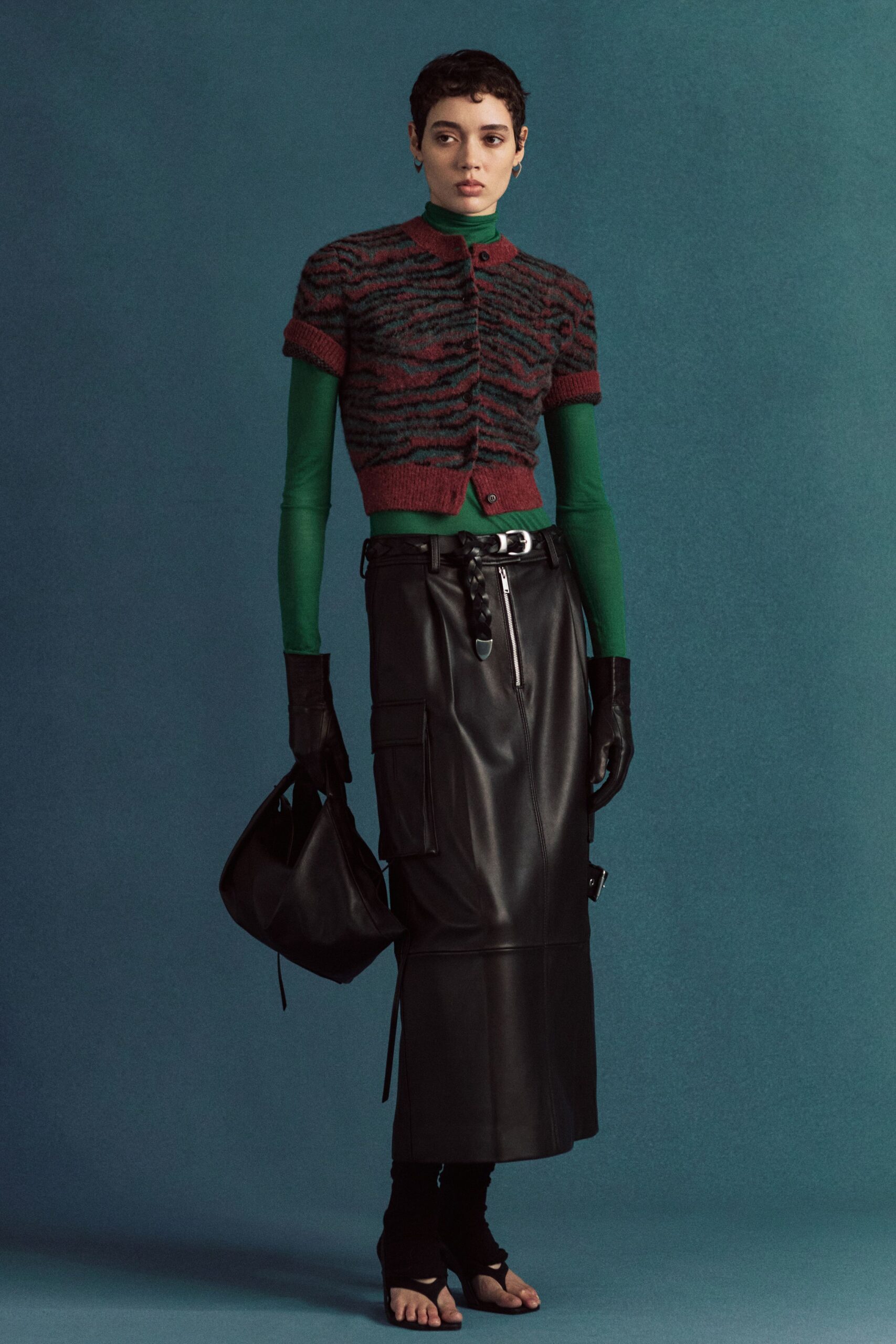 green fitted top with black leather skirt