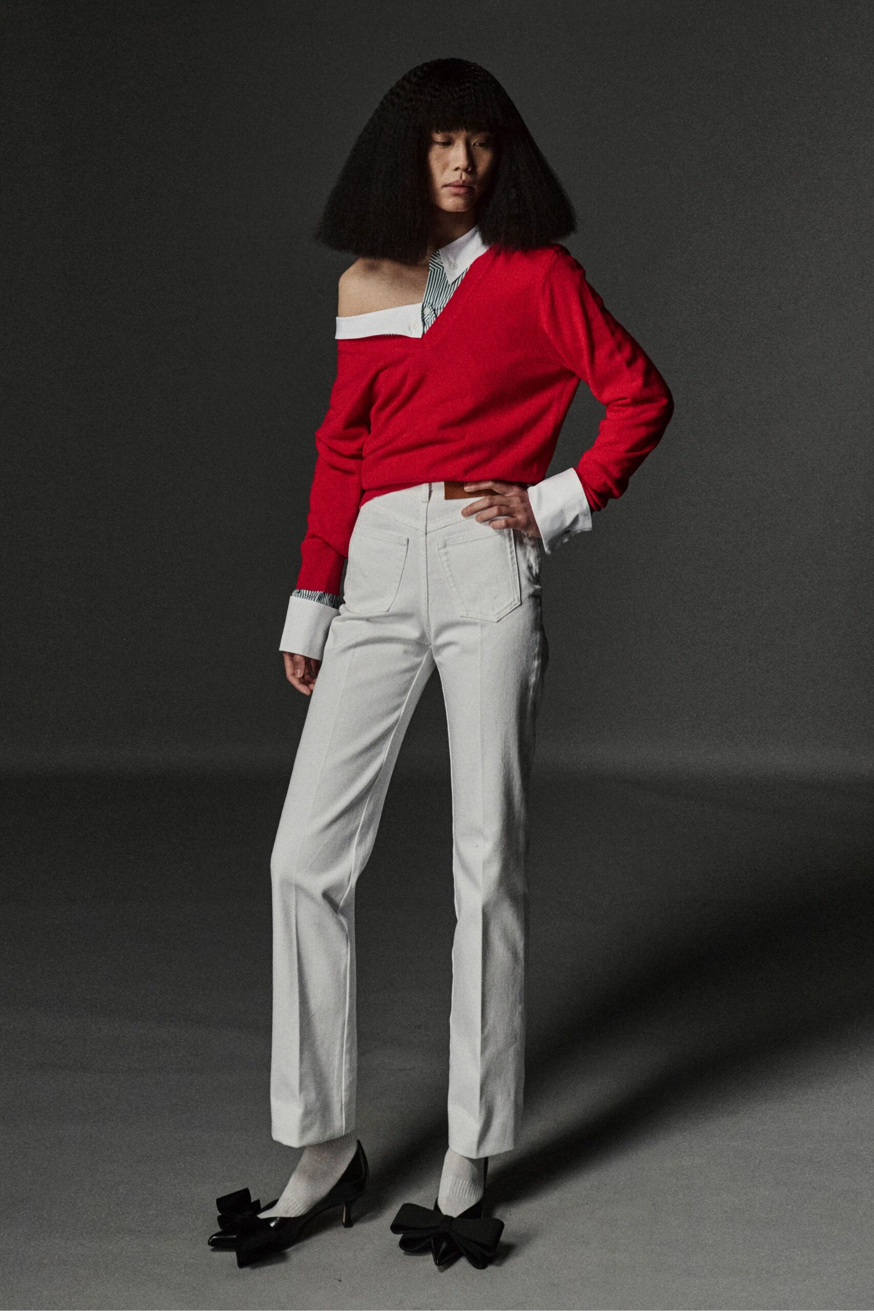 red off-shoulder sweater with white tailored pants