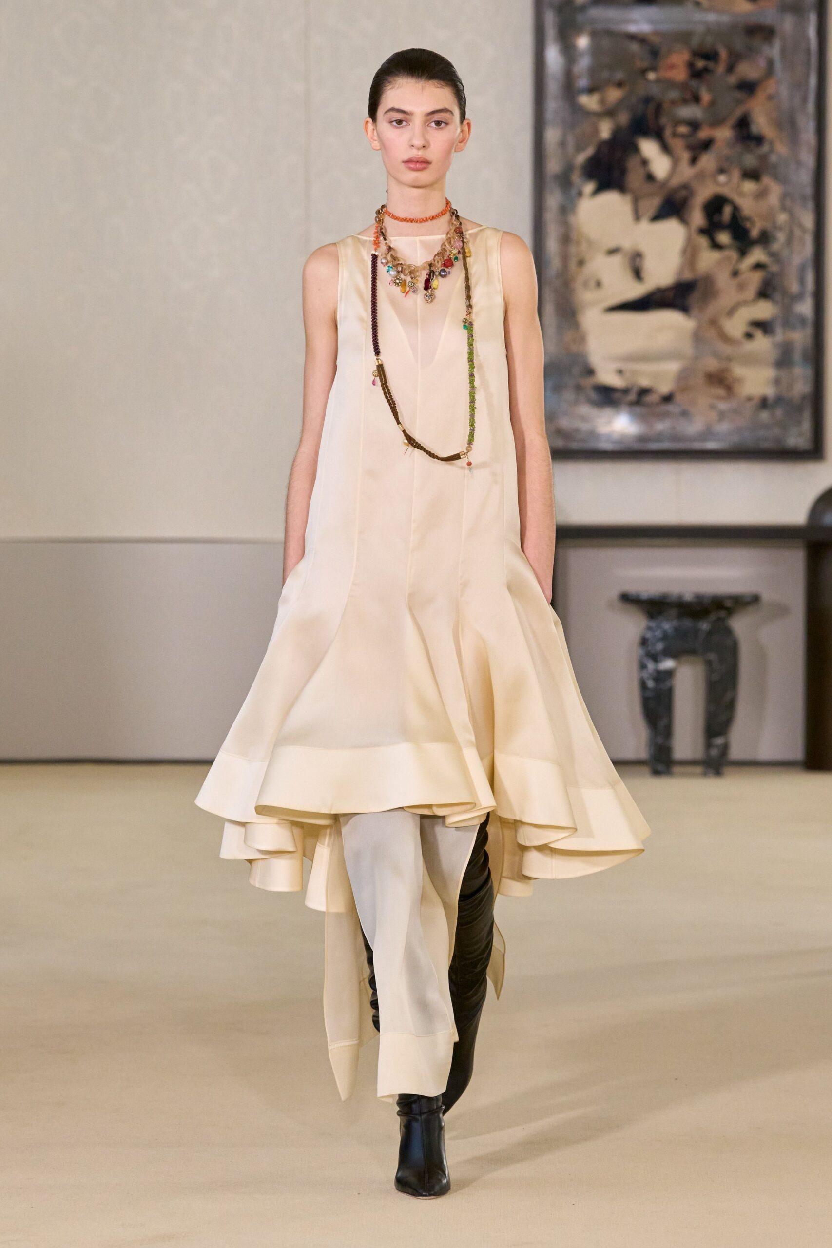 beige silk sleeveless high-neck fitted pleated flowing dress