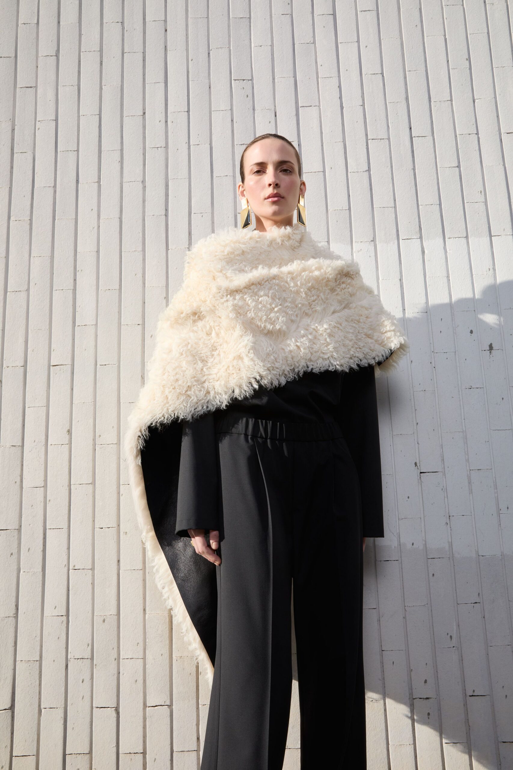 white faux-fur cape with black top and pants