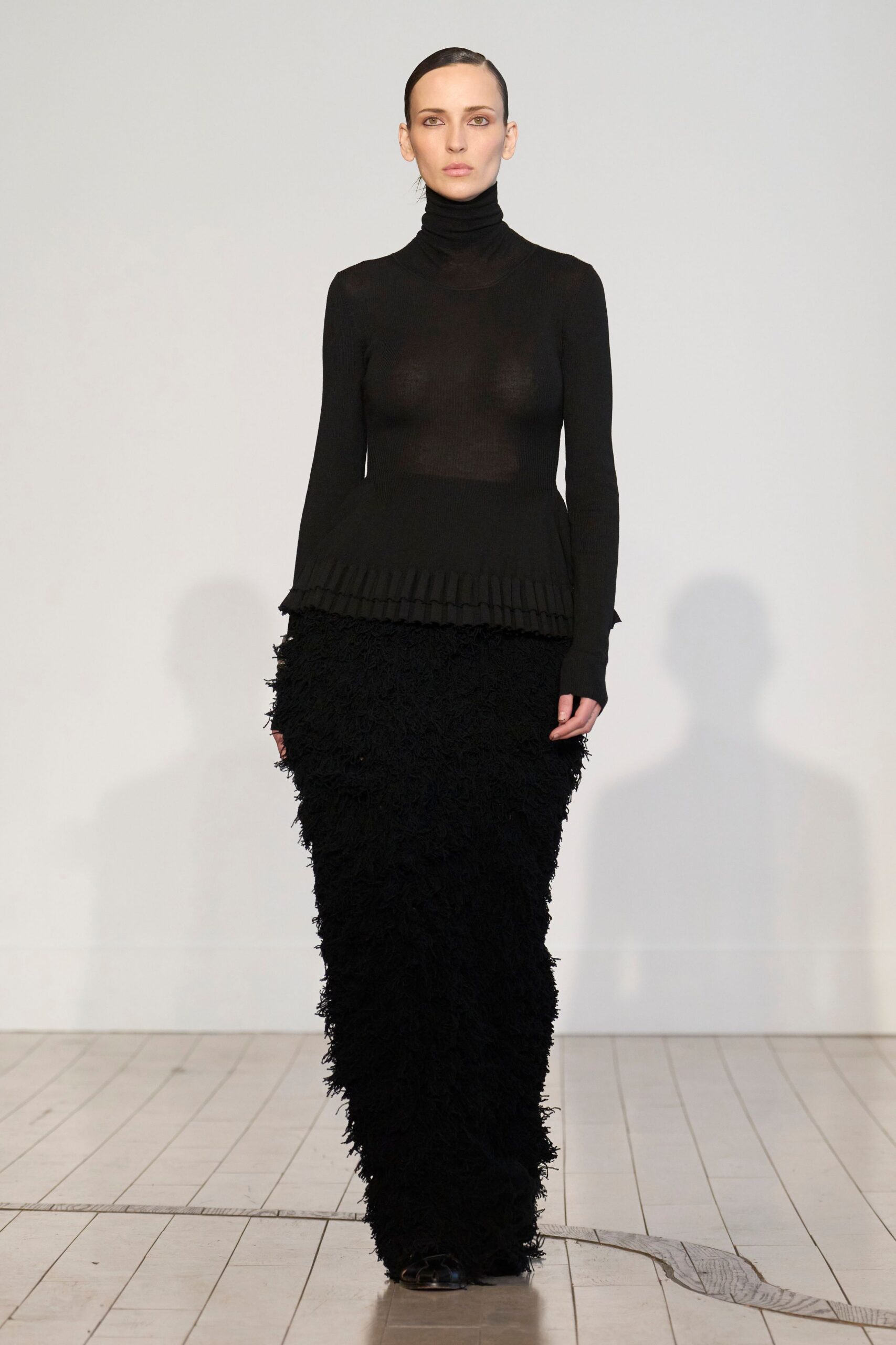 black fitted top and fringed skirt