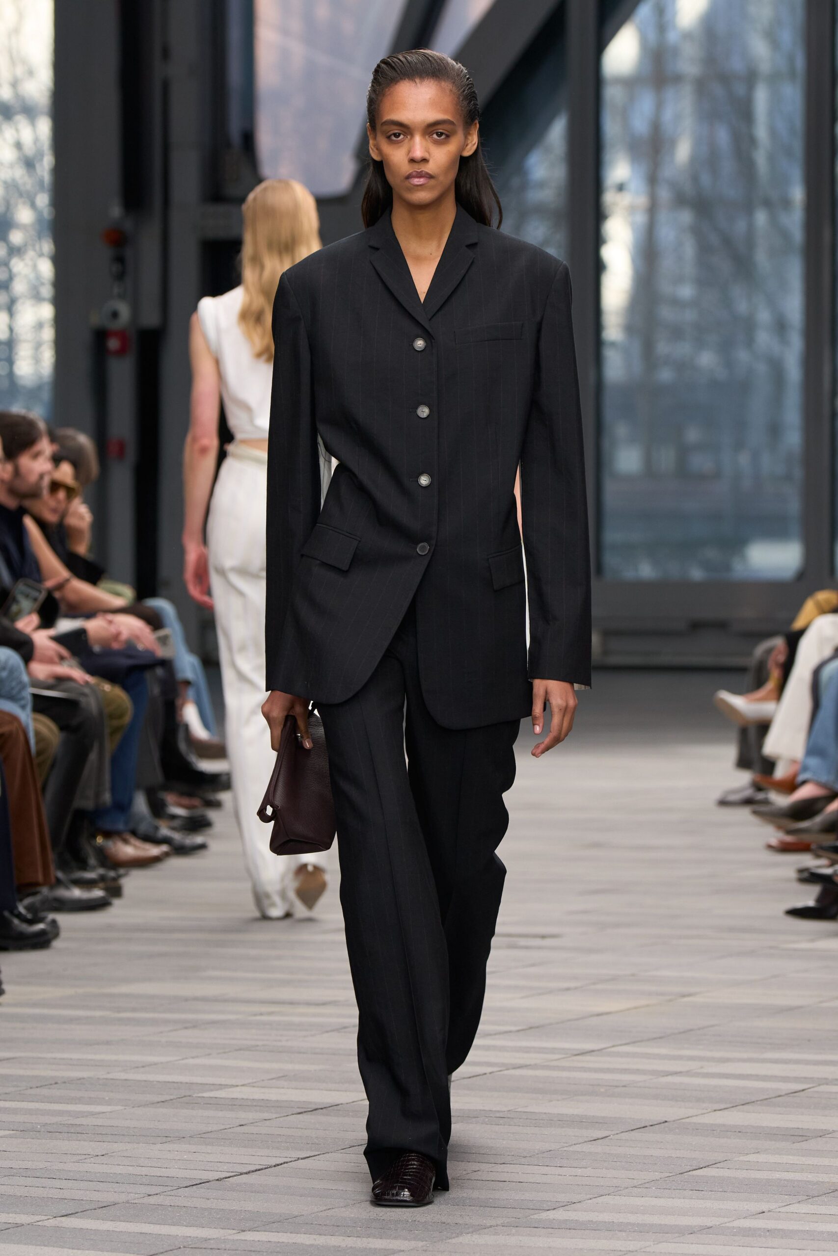 black tailored suit with brown bag