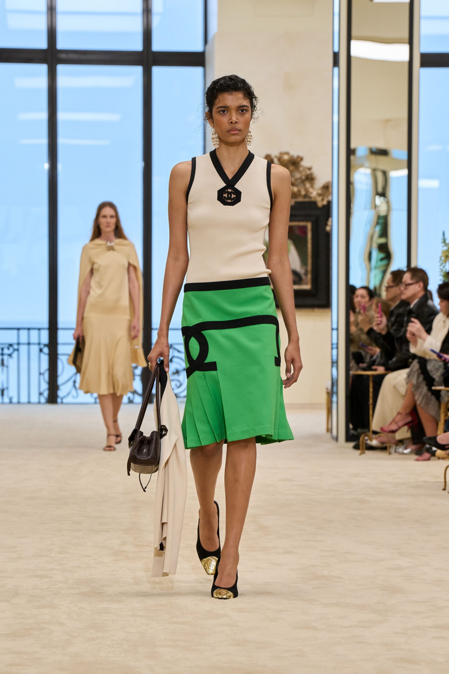 fitted white and black top with green pleated skirt