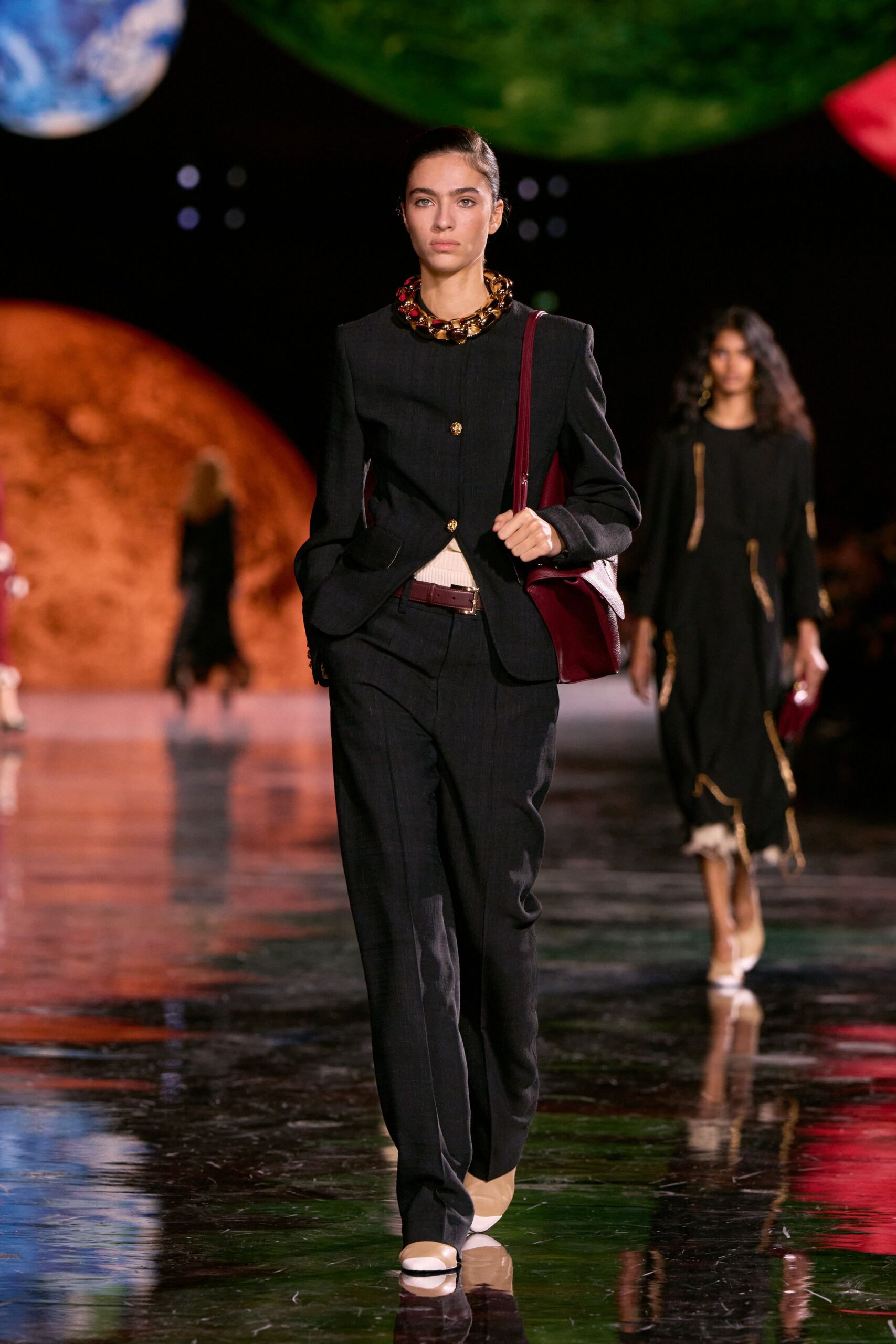 black tailored suit with red bag