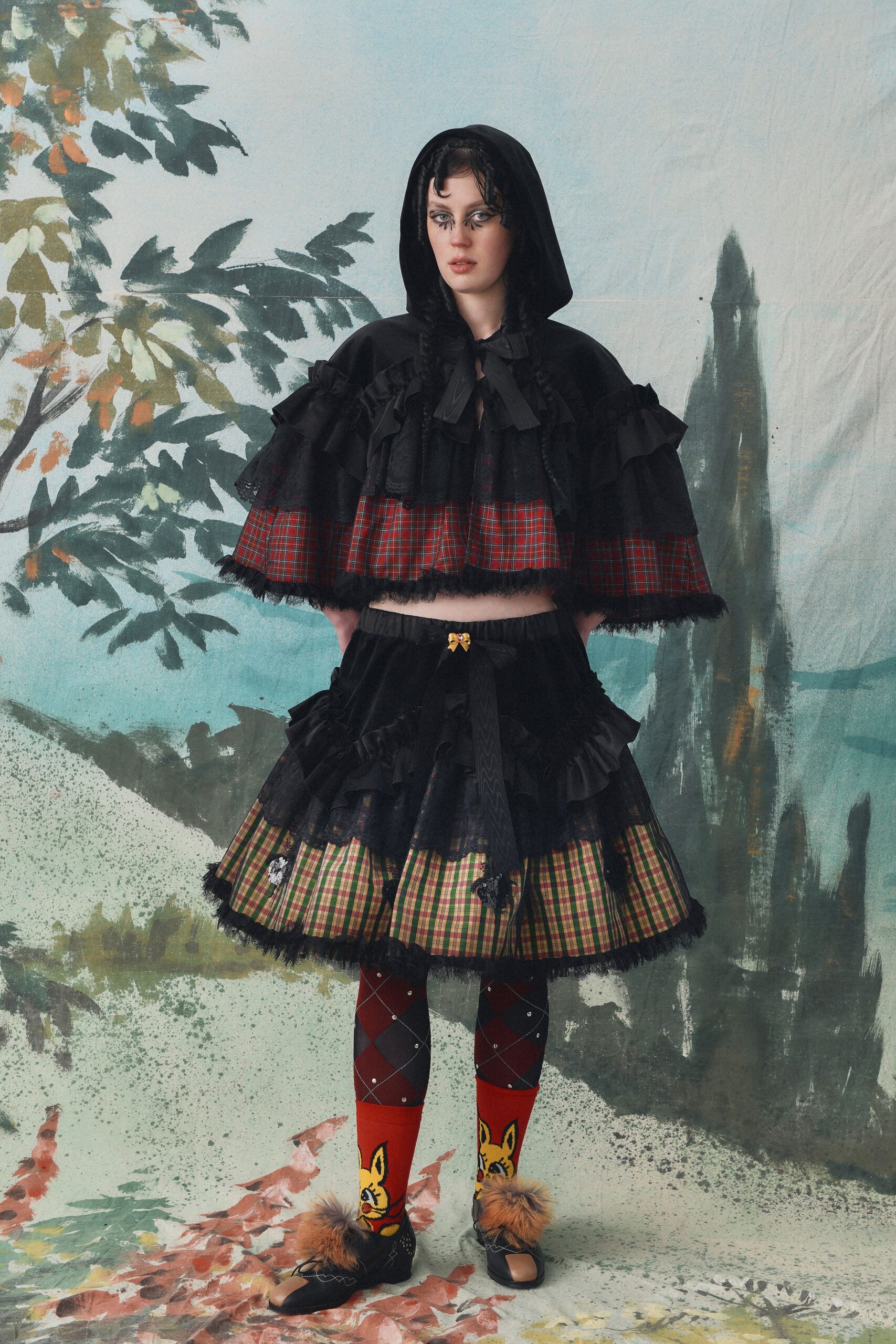 black ruffled cape with plaid skirt