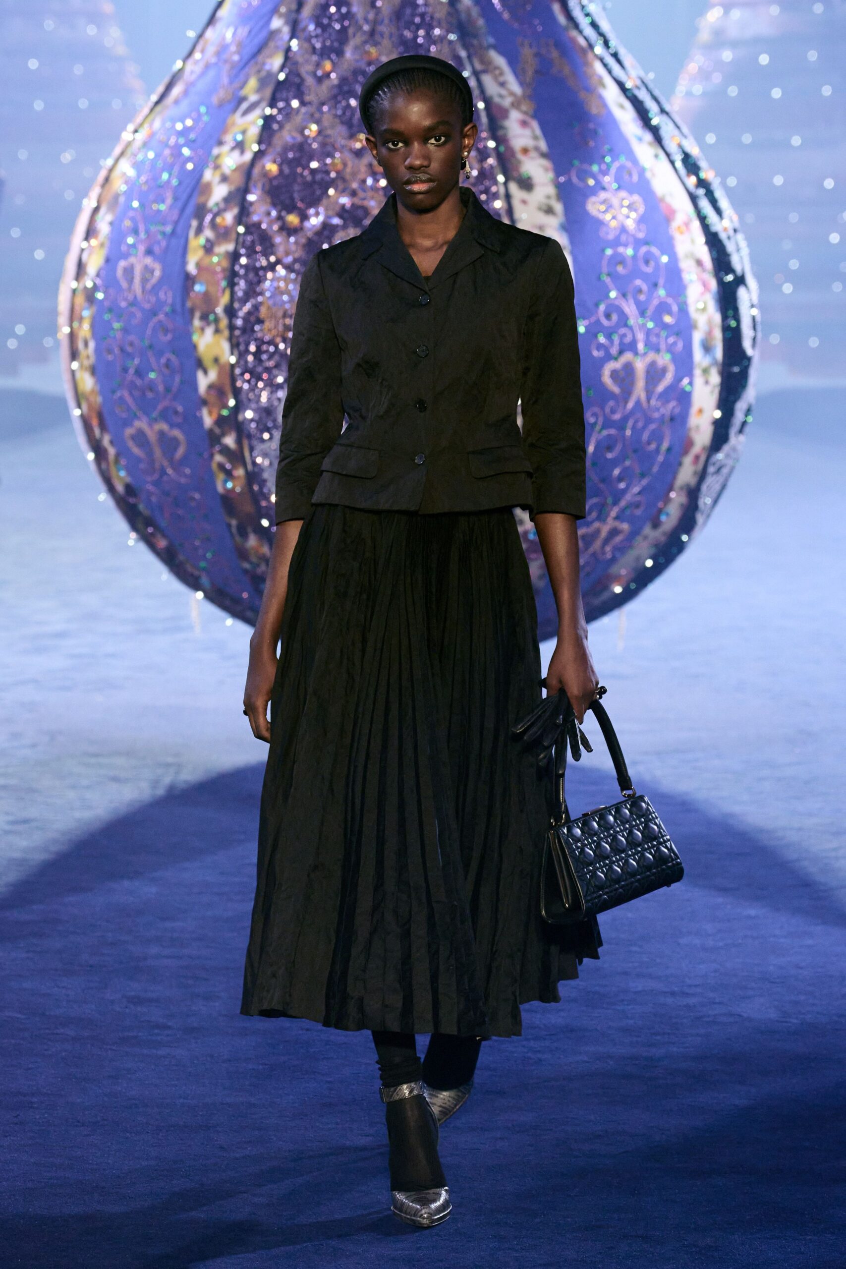 black silk jacket and pleated skirt