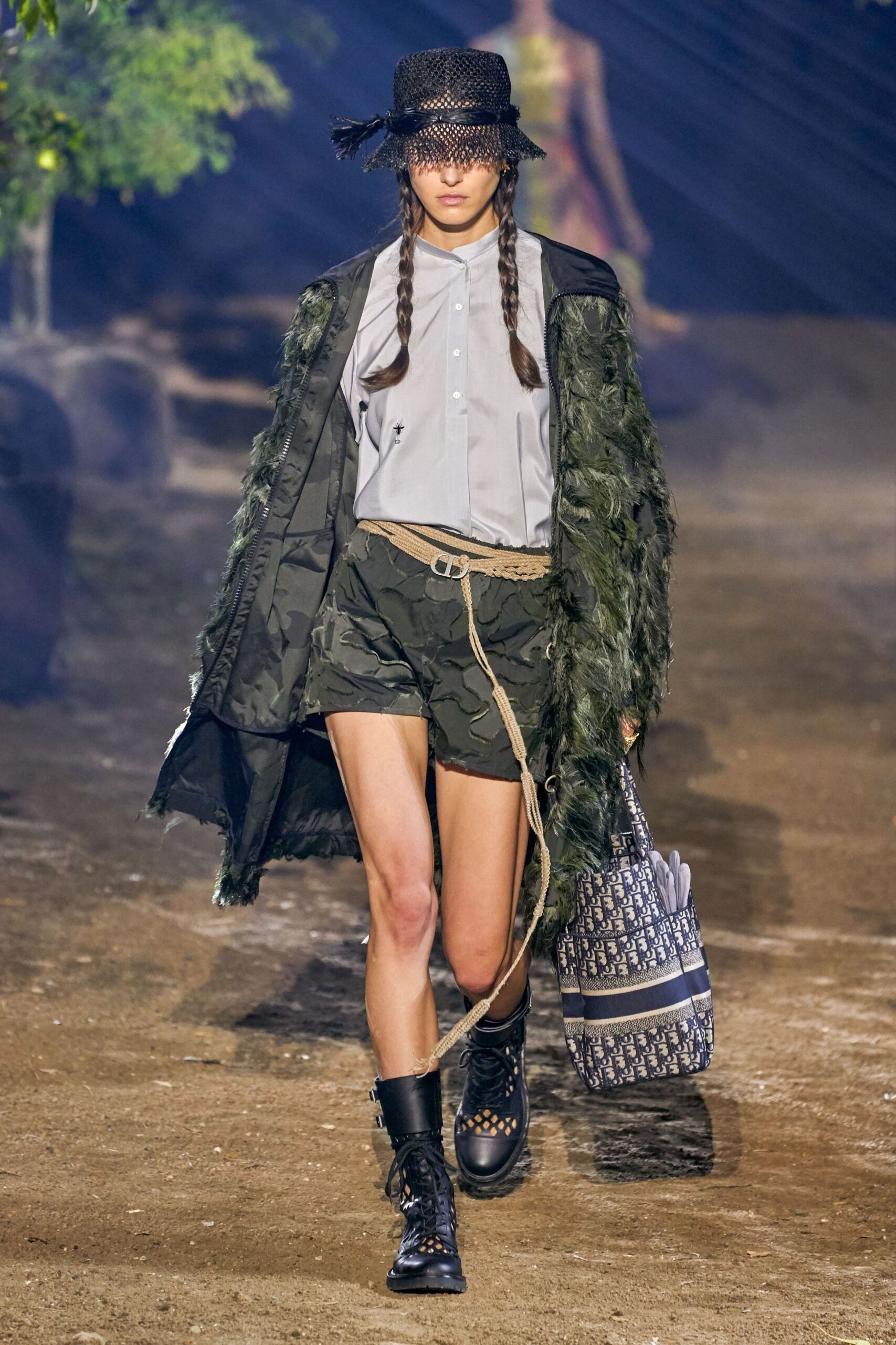 black faux-fur coat with camouflage shorts