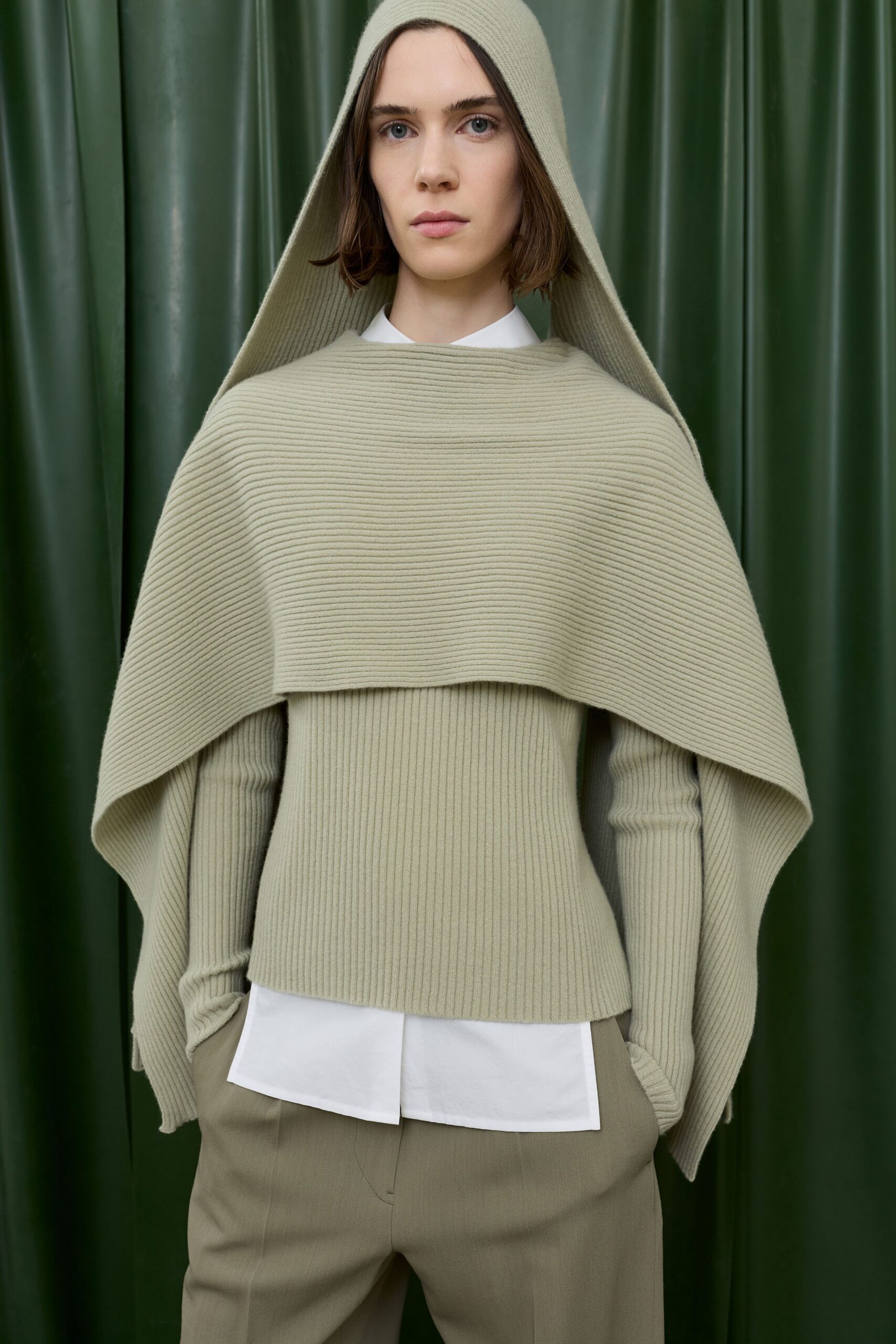 green hooded top with beige pants