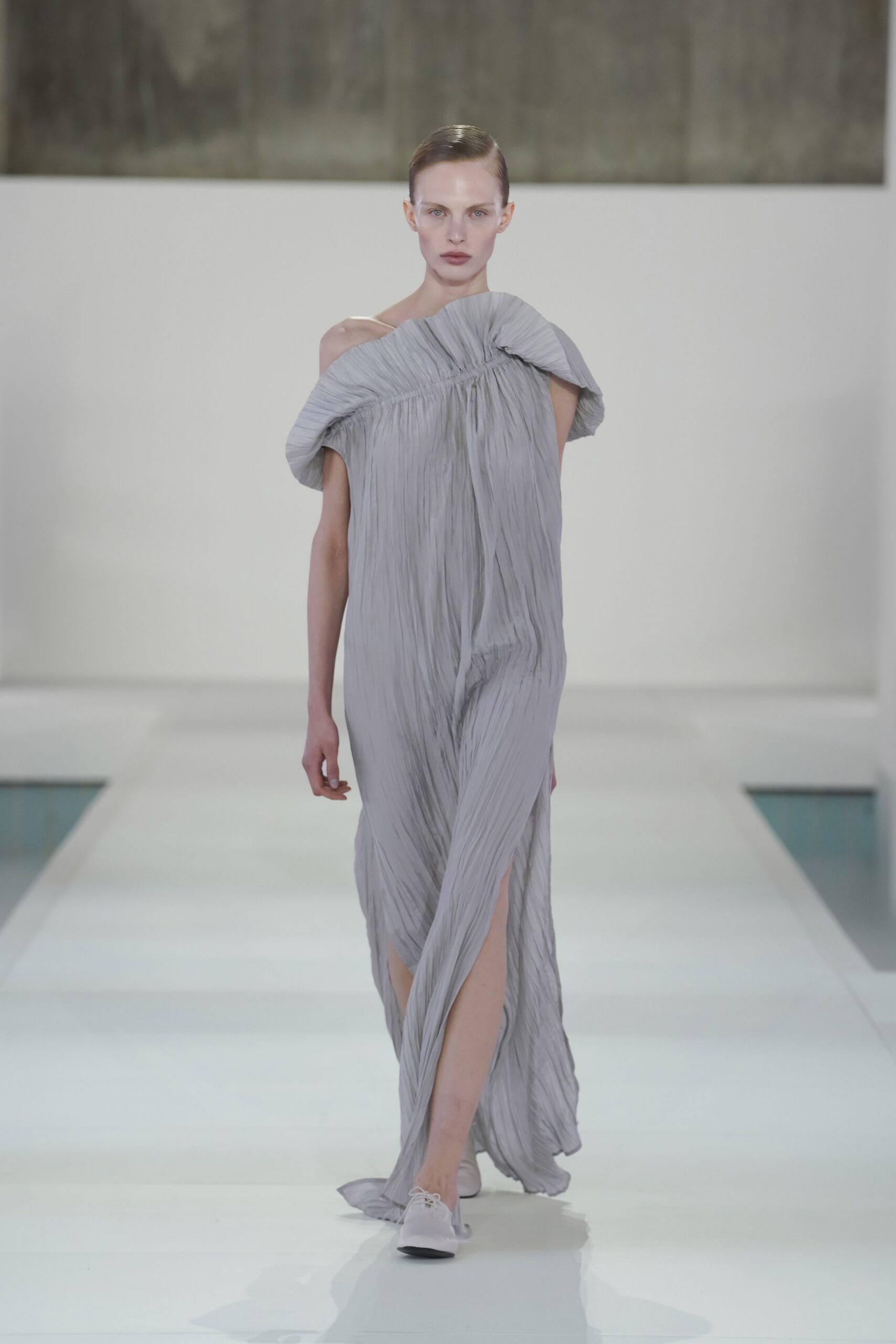 gray silk sleeveless off-shoulder fitted pleated flowing gown