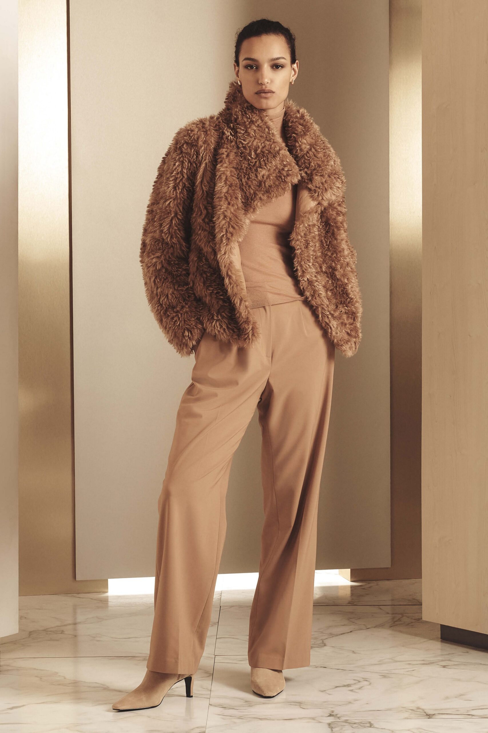 brown faux-fur coat with beige top and tan pants