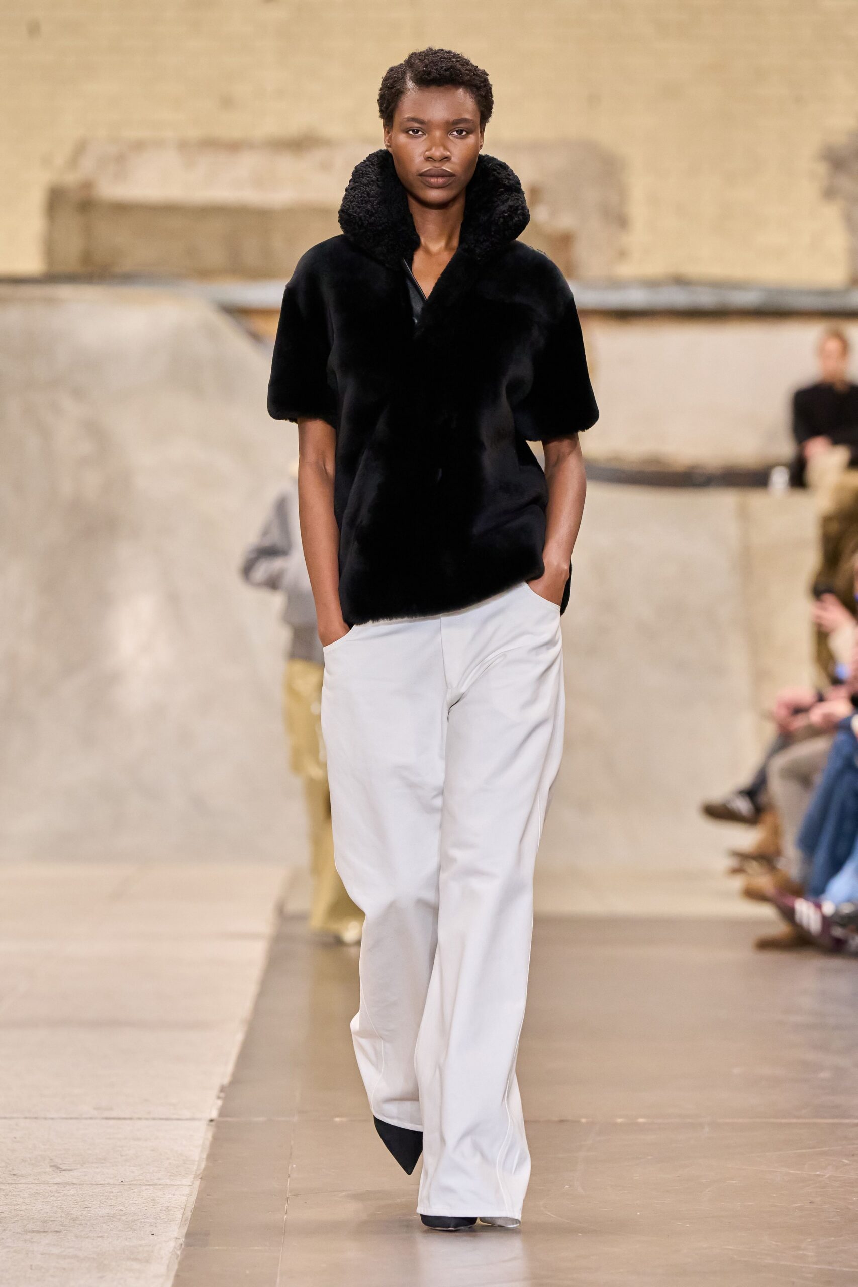black faux-fur jacket with white pants