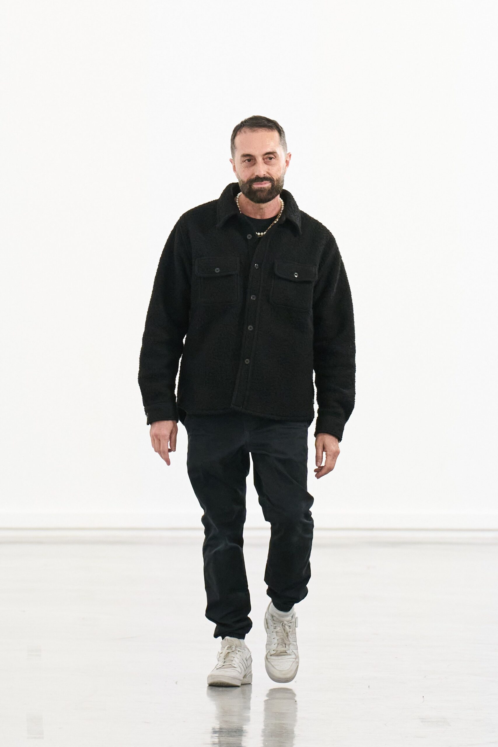 black faux-fur jacket with black pants and white shoes