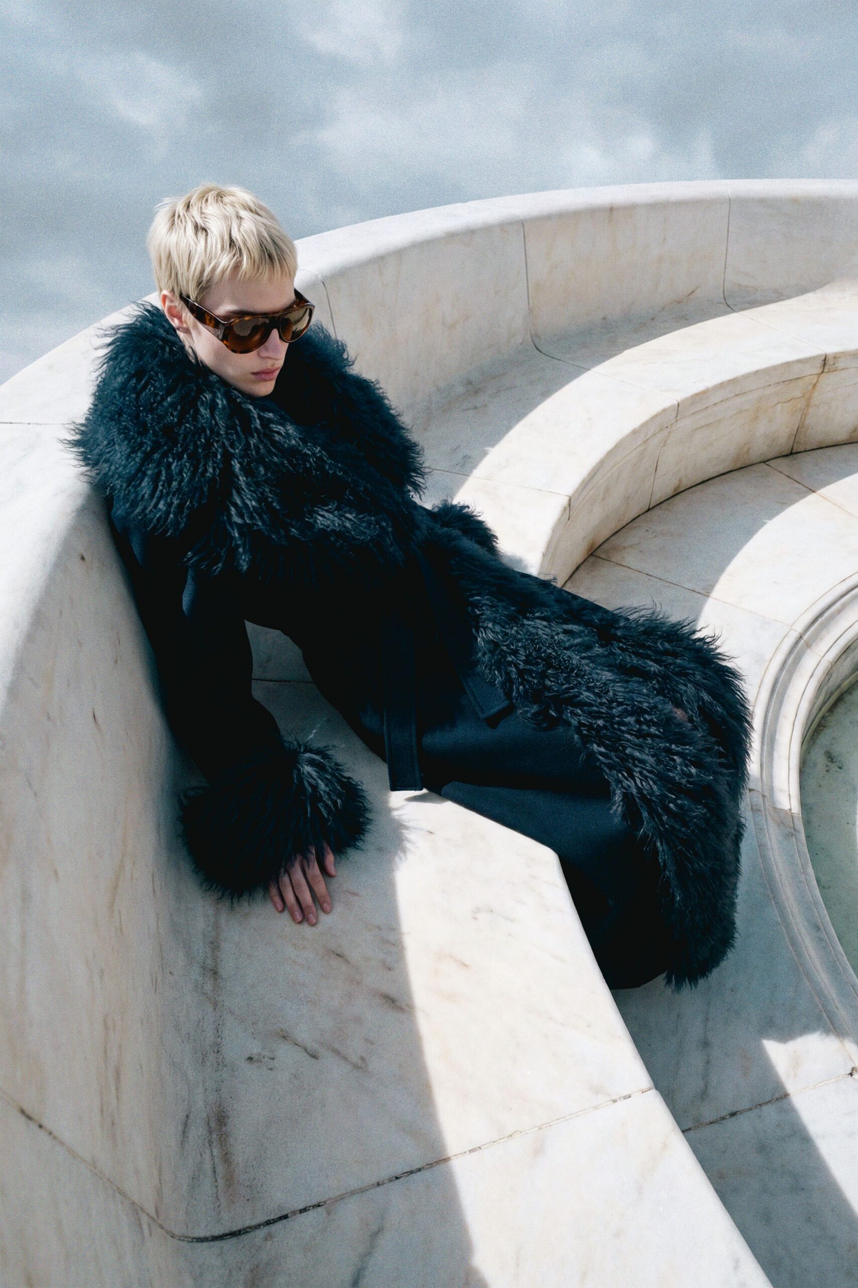 black faux-fur coat with sunglasses