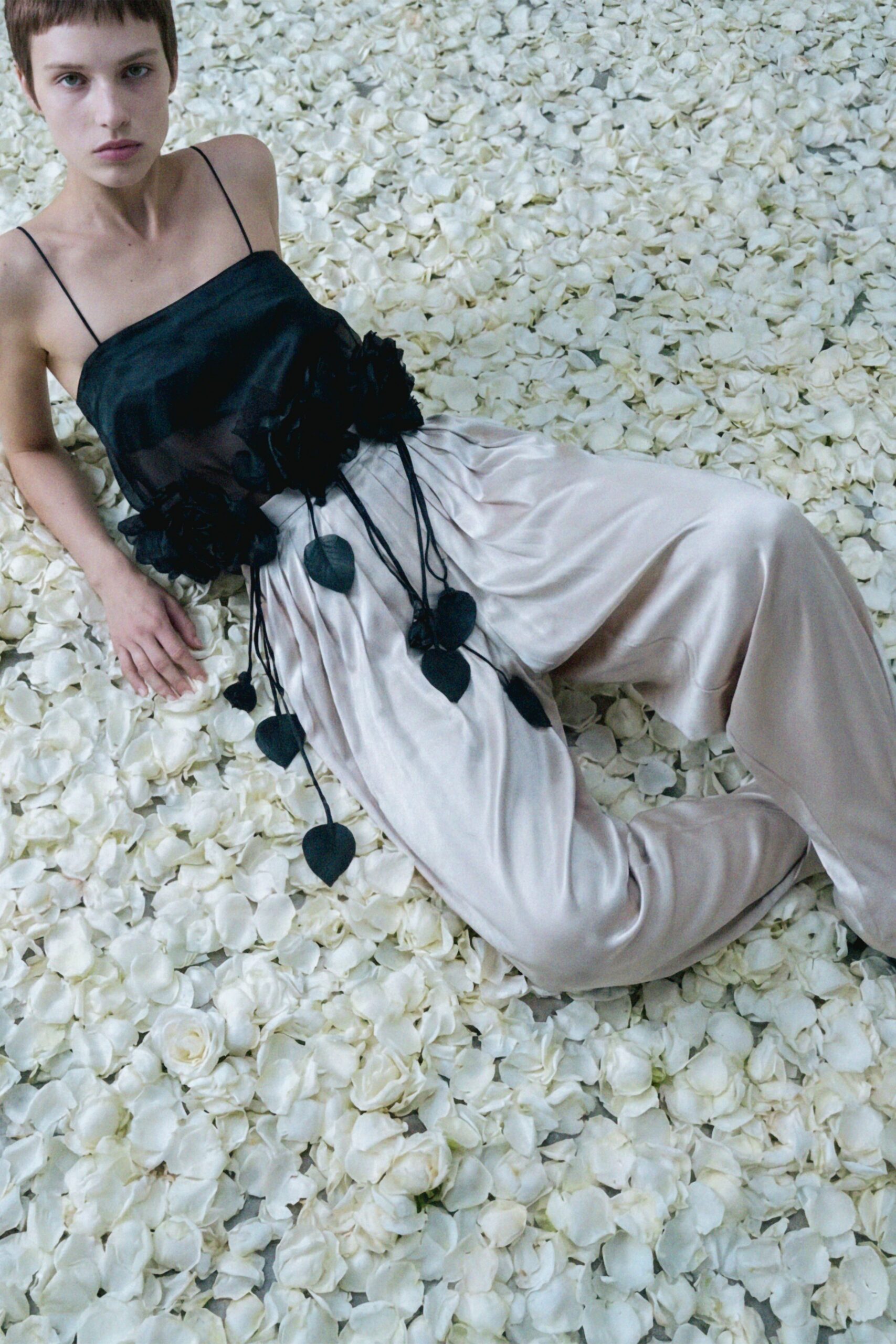 black silk ruffled top and beige pants