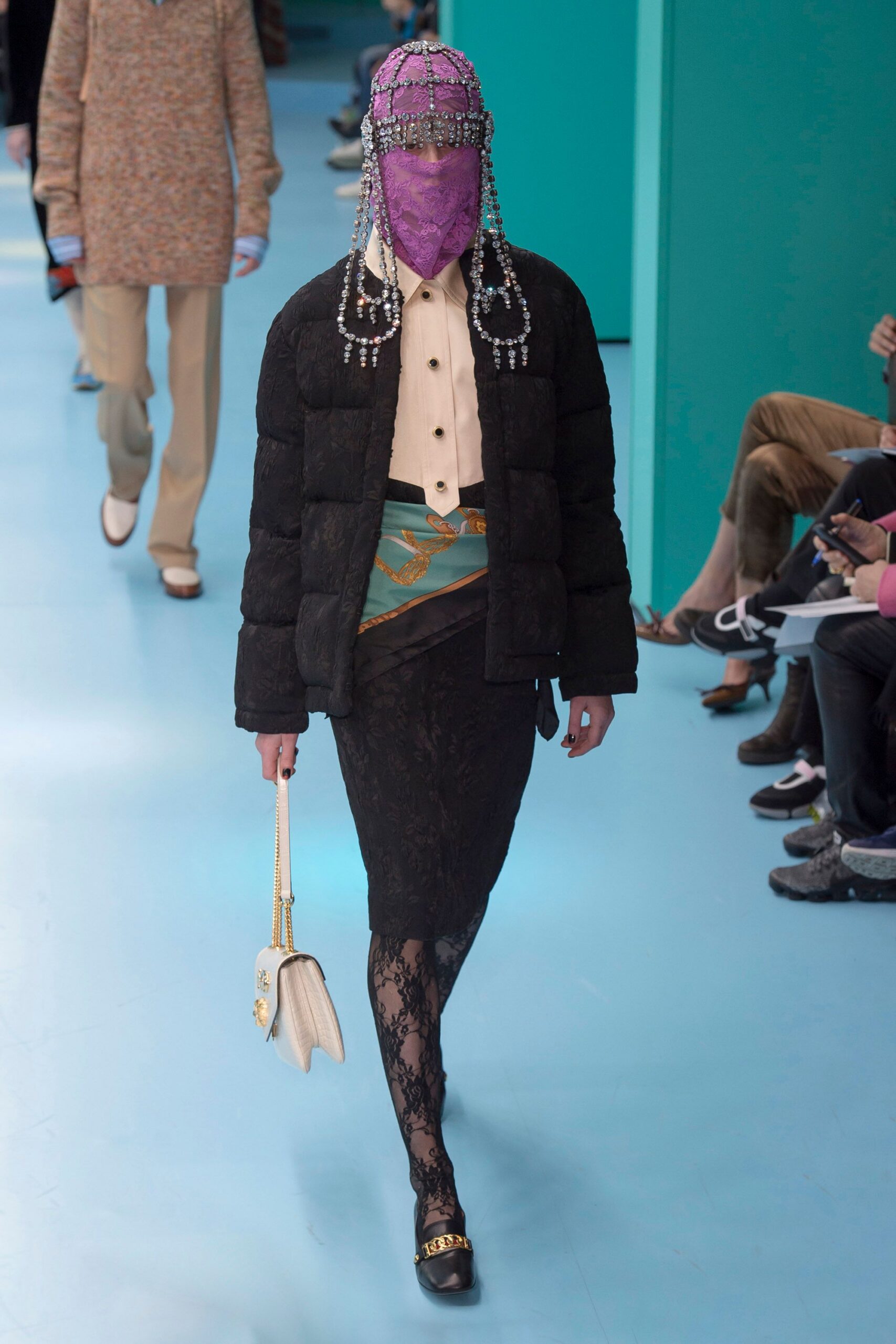 black puffer jacket beige shirt black lace skirt