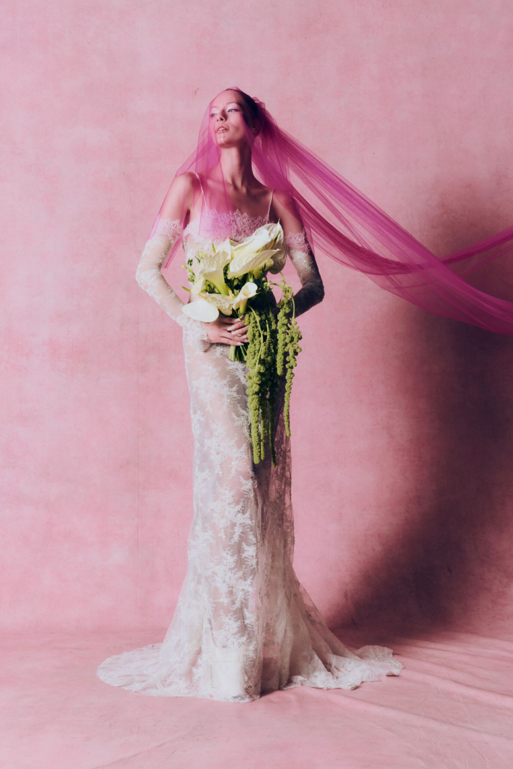 white lace fitted gown with pink veil