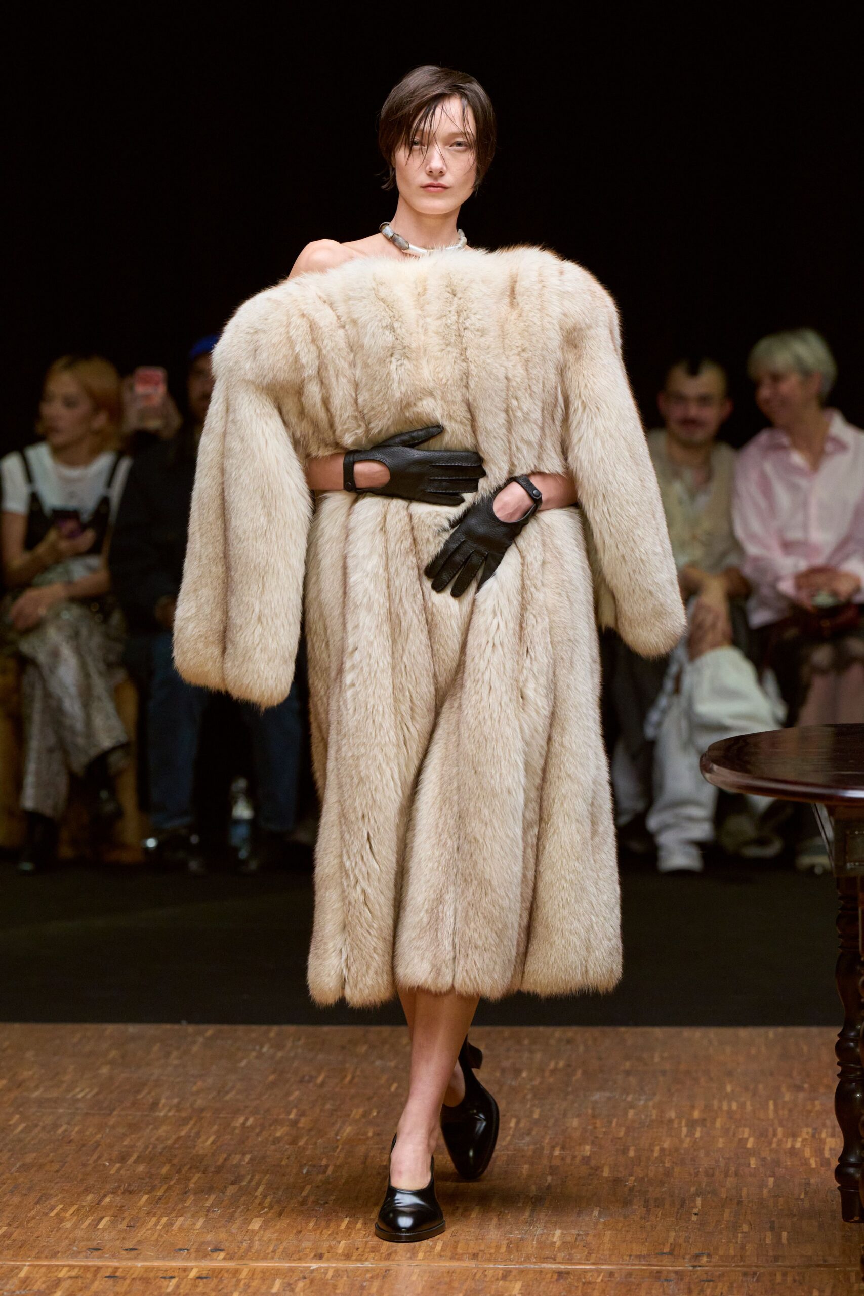 beige fur coat with black gloves