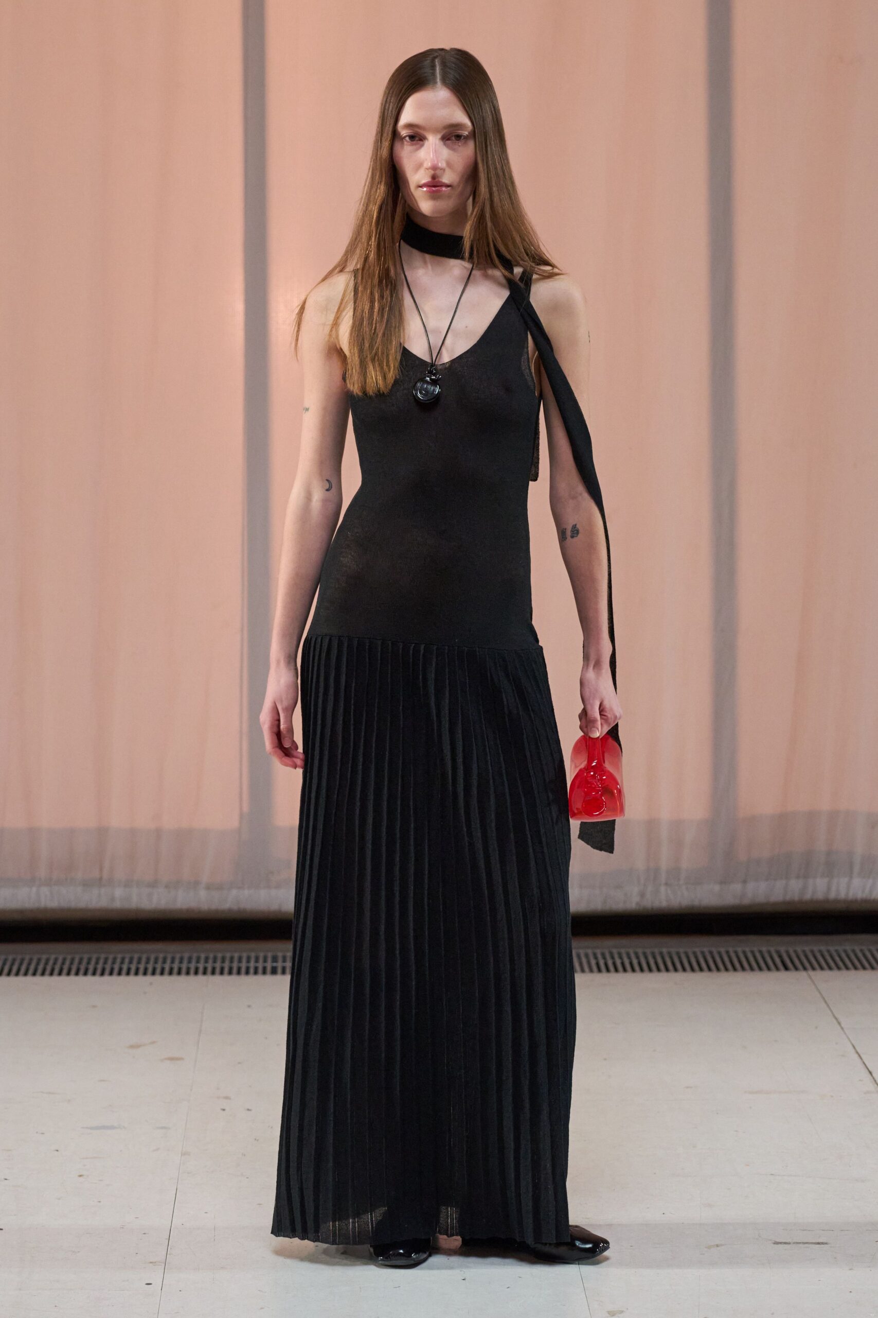 black fitted sleeveless dress with red bag