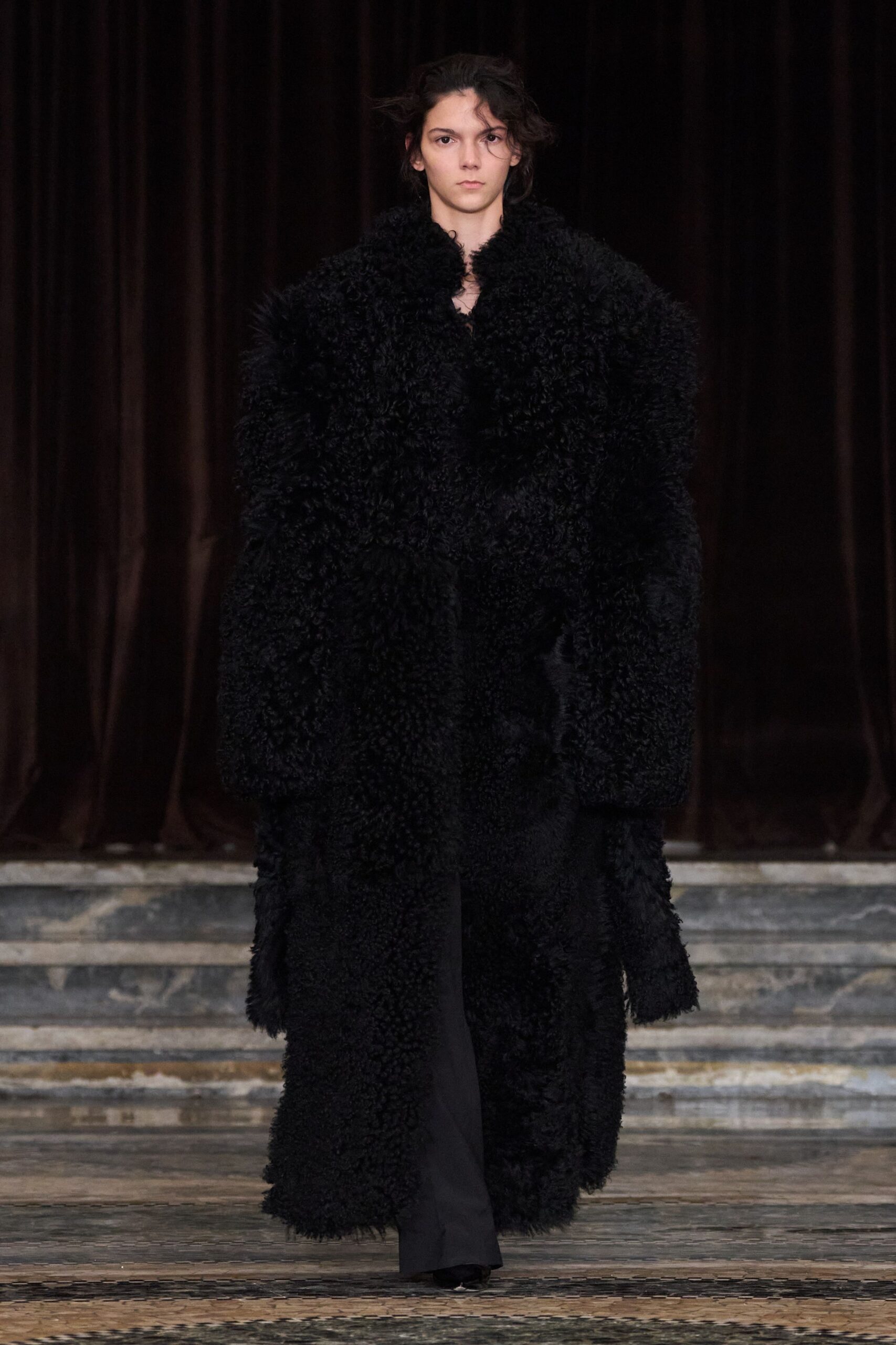black oversized fur coat and fitted pants