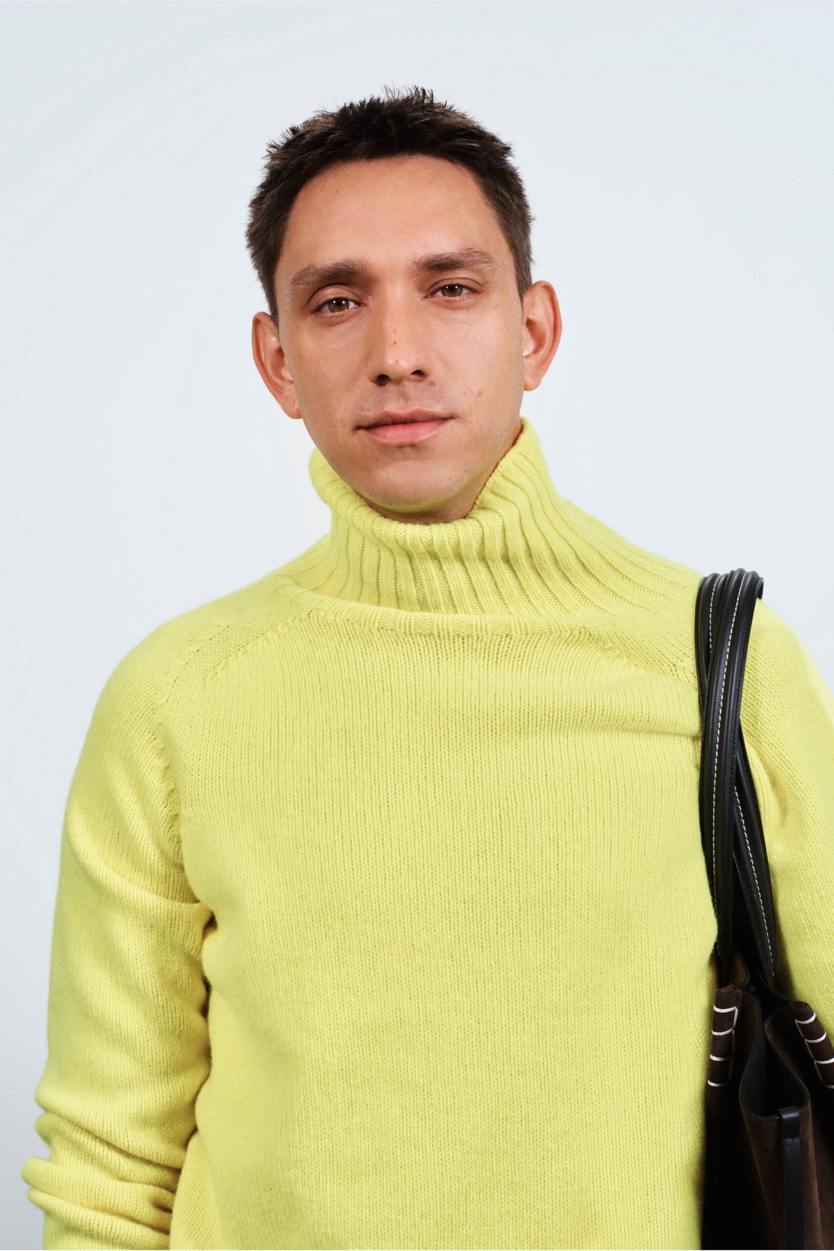 yellow fitted turtleneck sweater with black bag