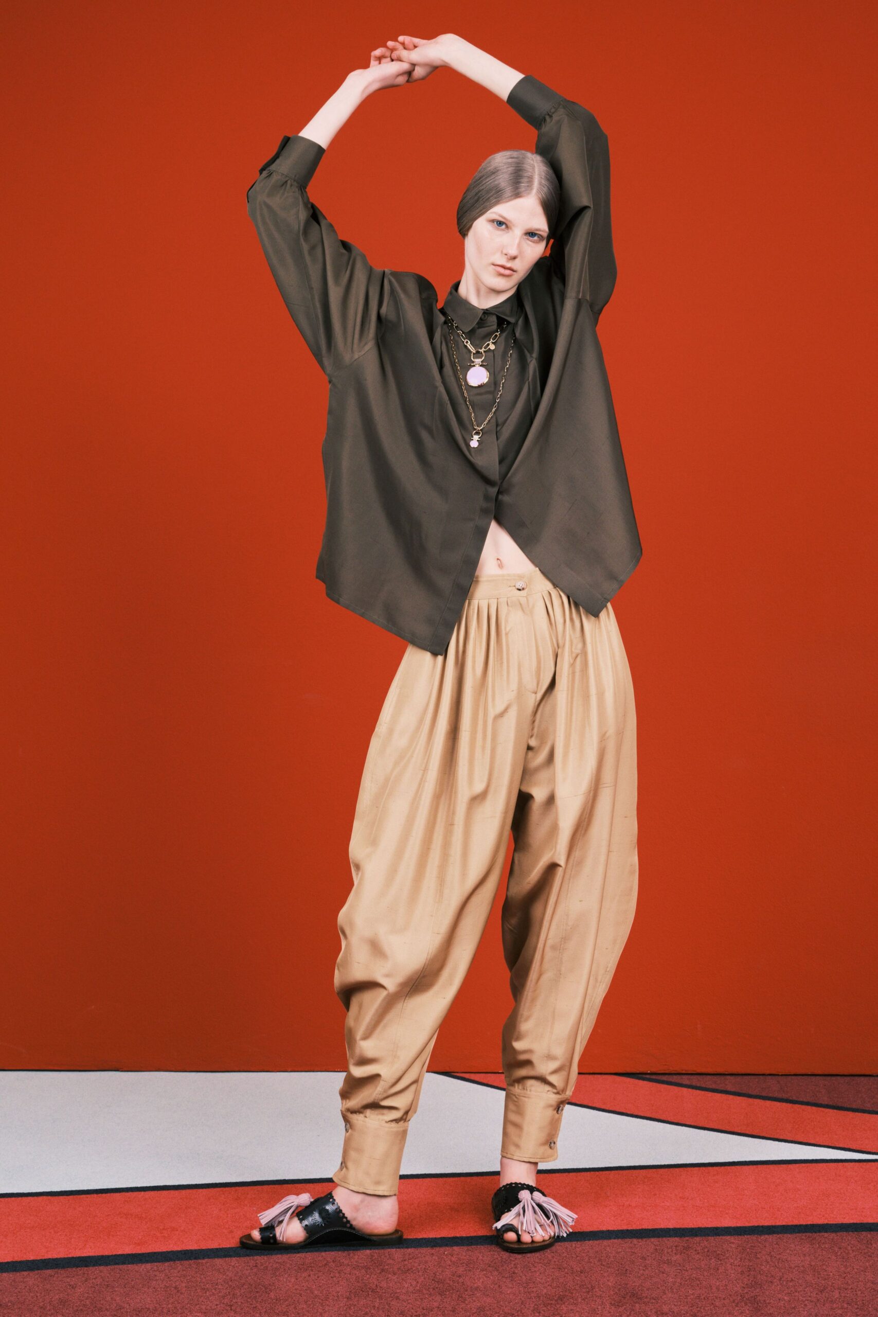 black silk relaxed top with beige pleated pants