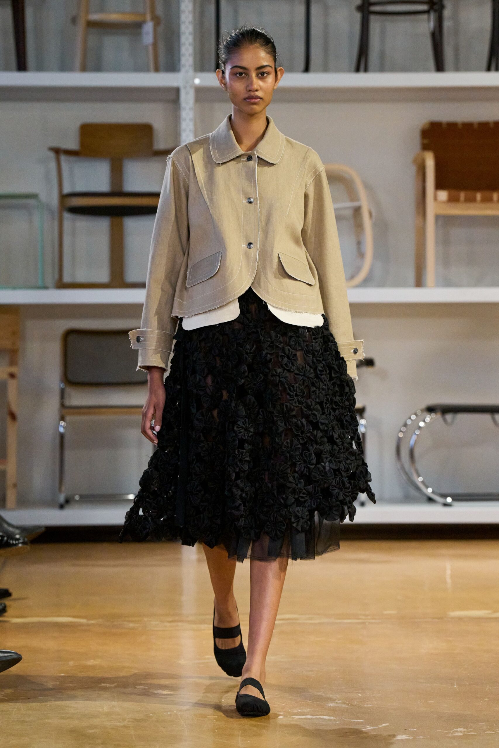 beige structured jacket black pleated skirt