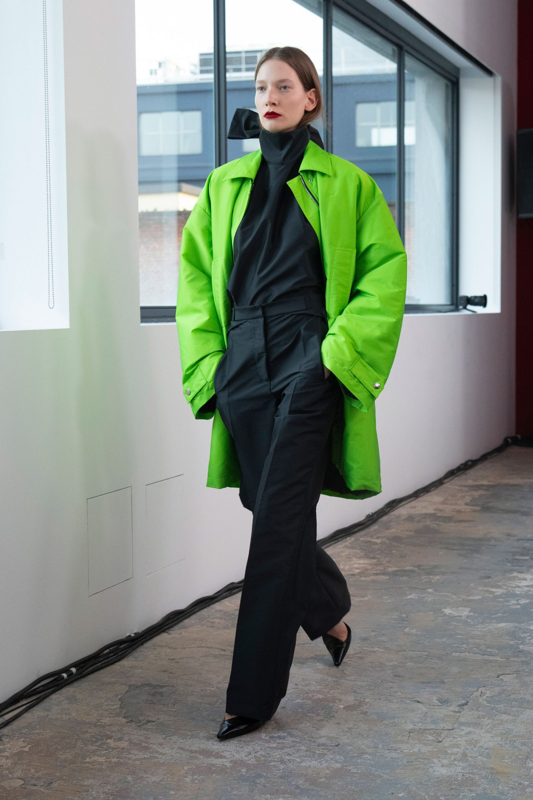 green oversized coat with black top and pants