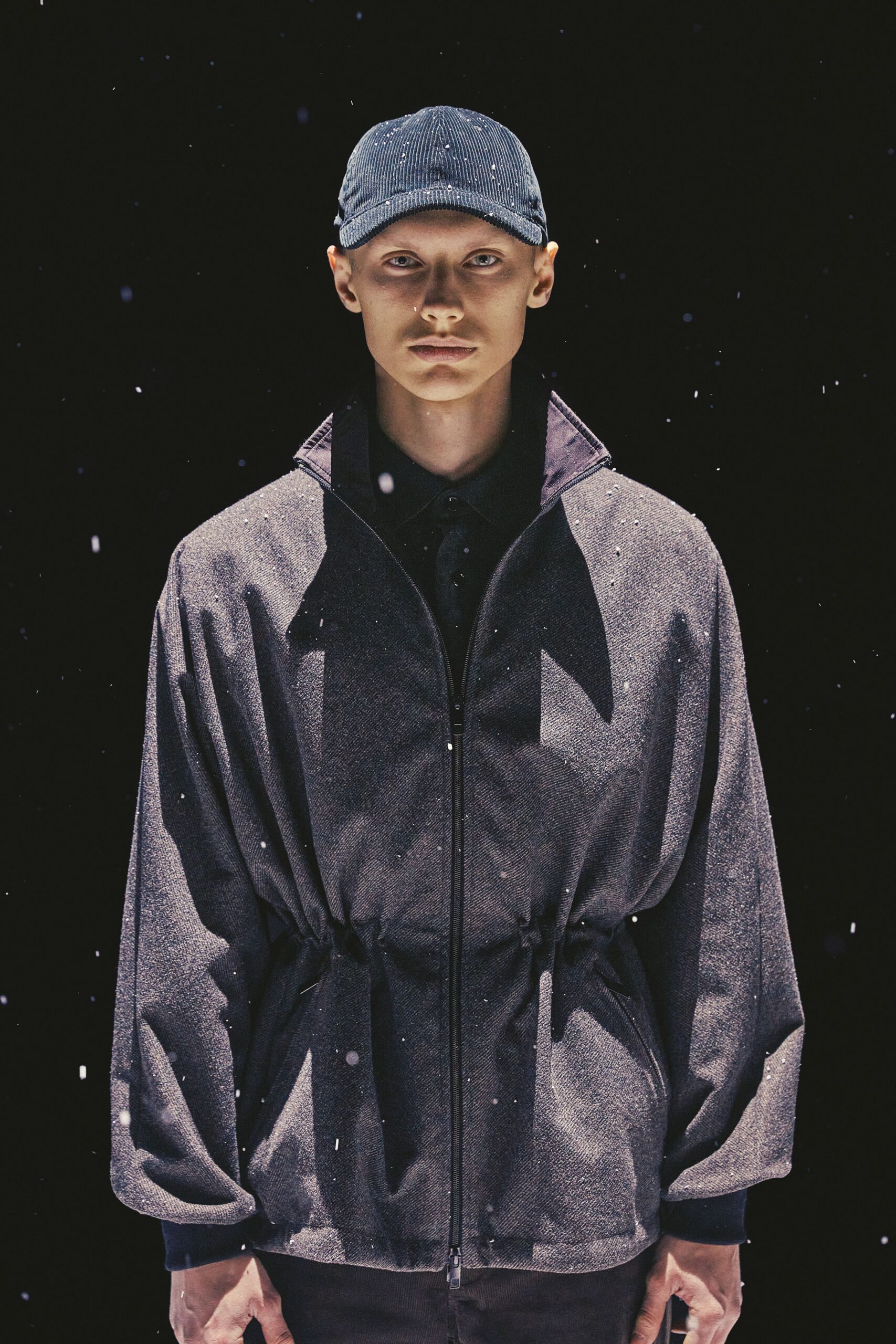 black relaxed jacket and blue cap