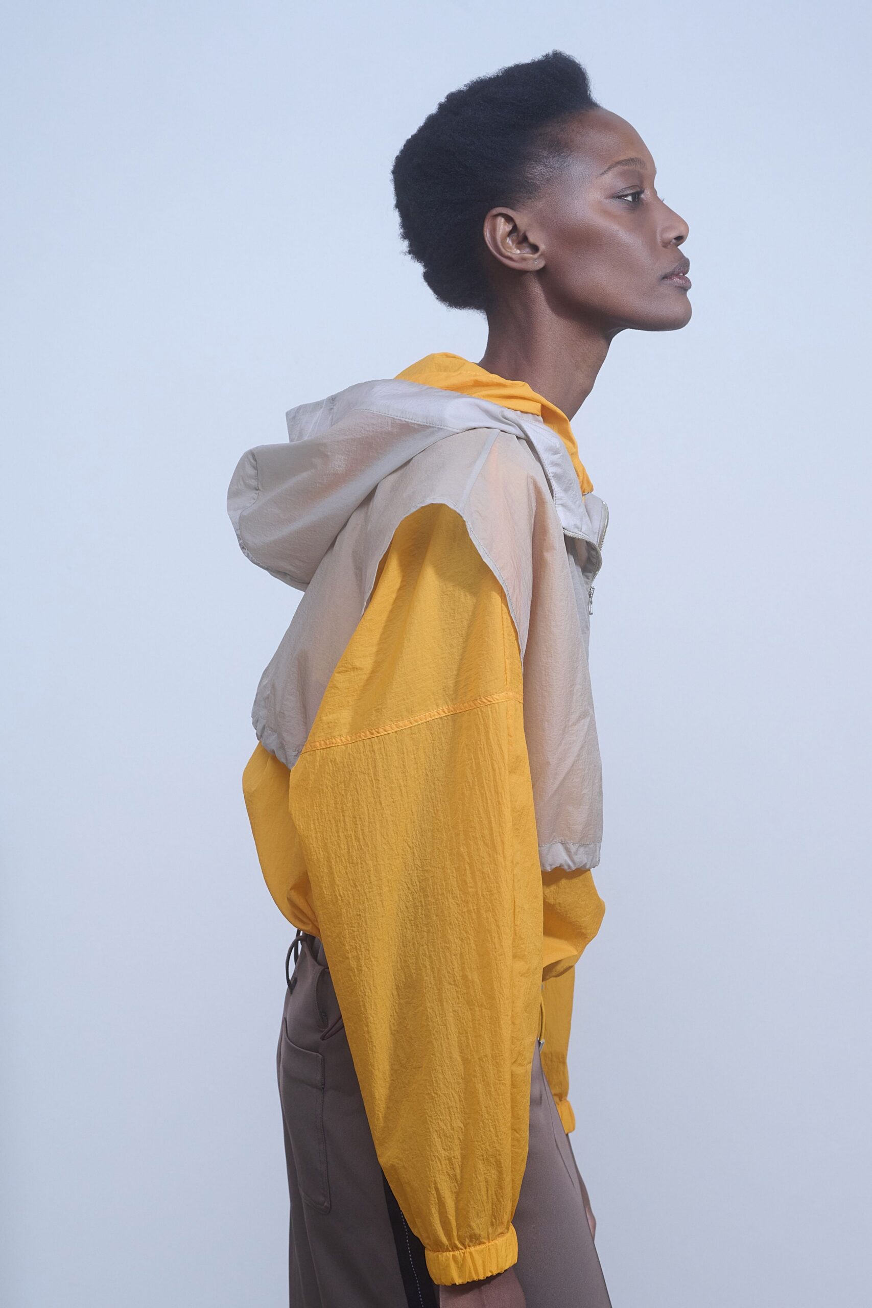 yellow beige hooded jacket with brown pants