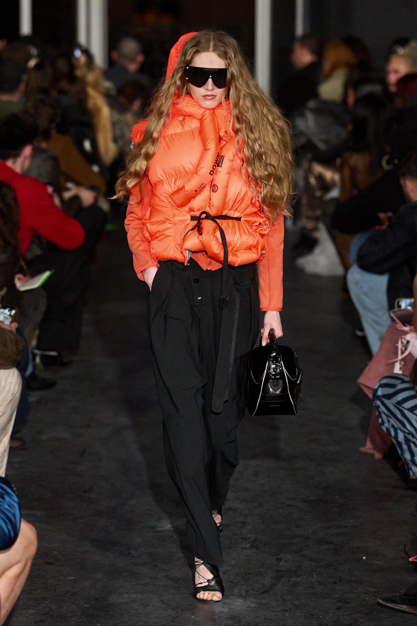 orange padded jacket with black pants