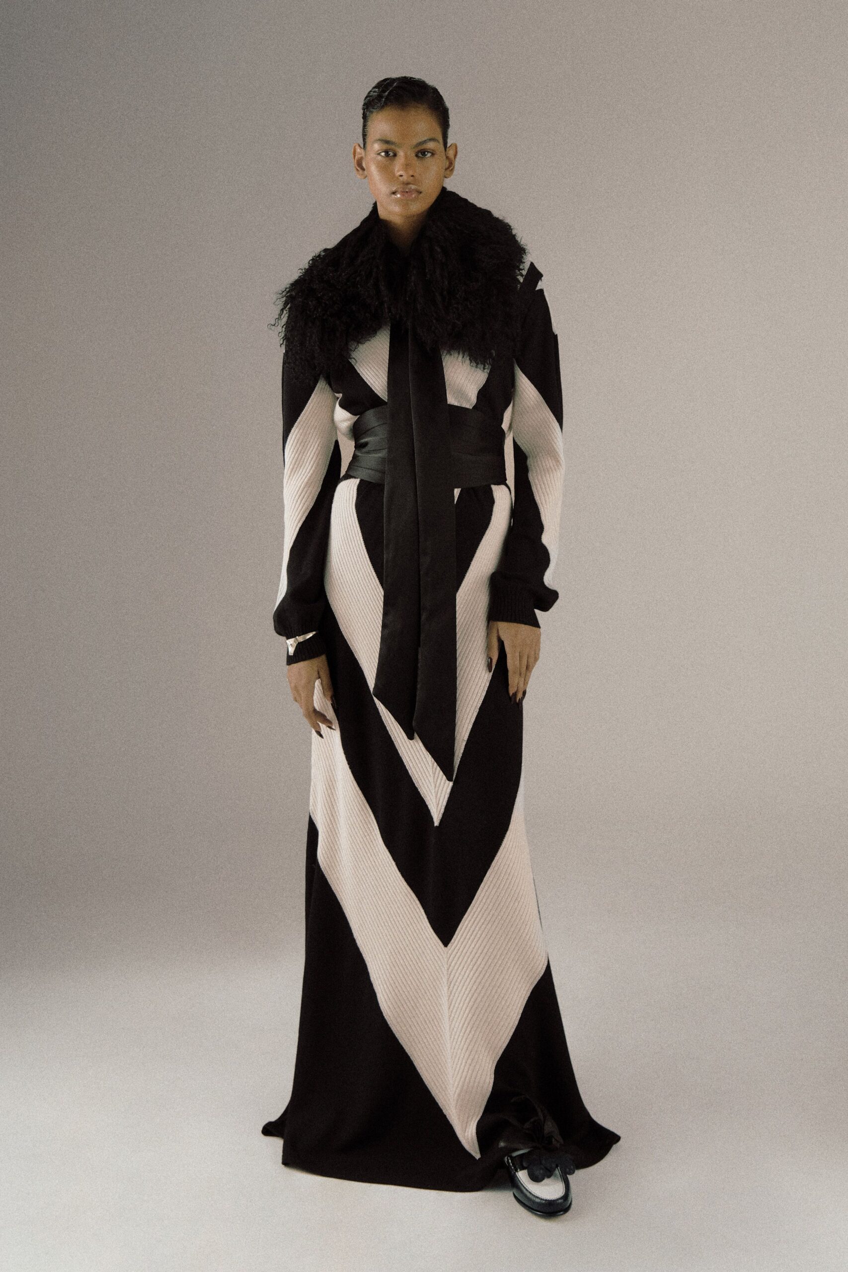 black and beige pleated gown with fur coat