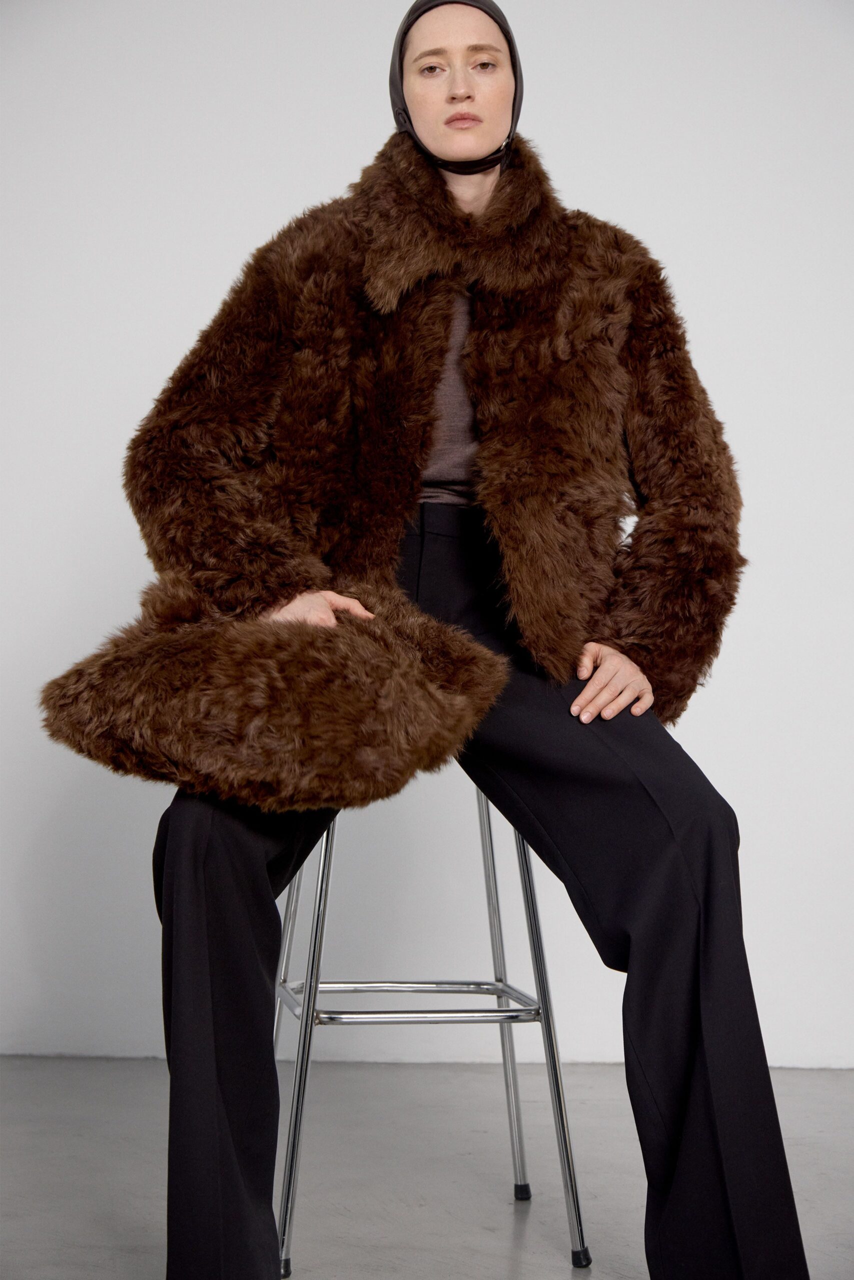 brown faux-fur coat and black tailored pants
