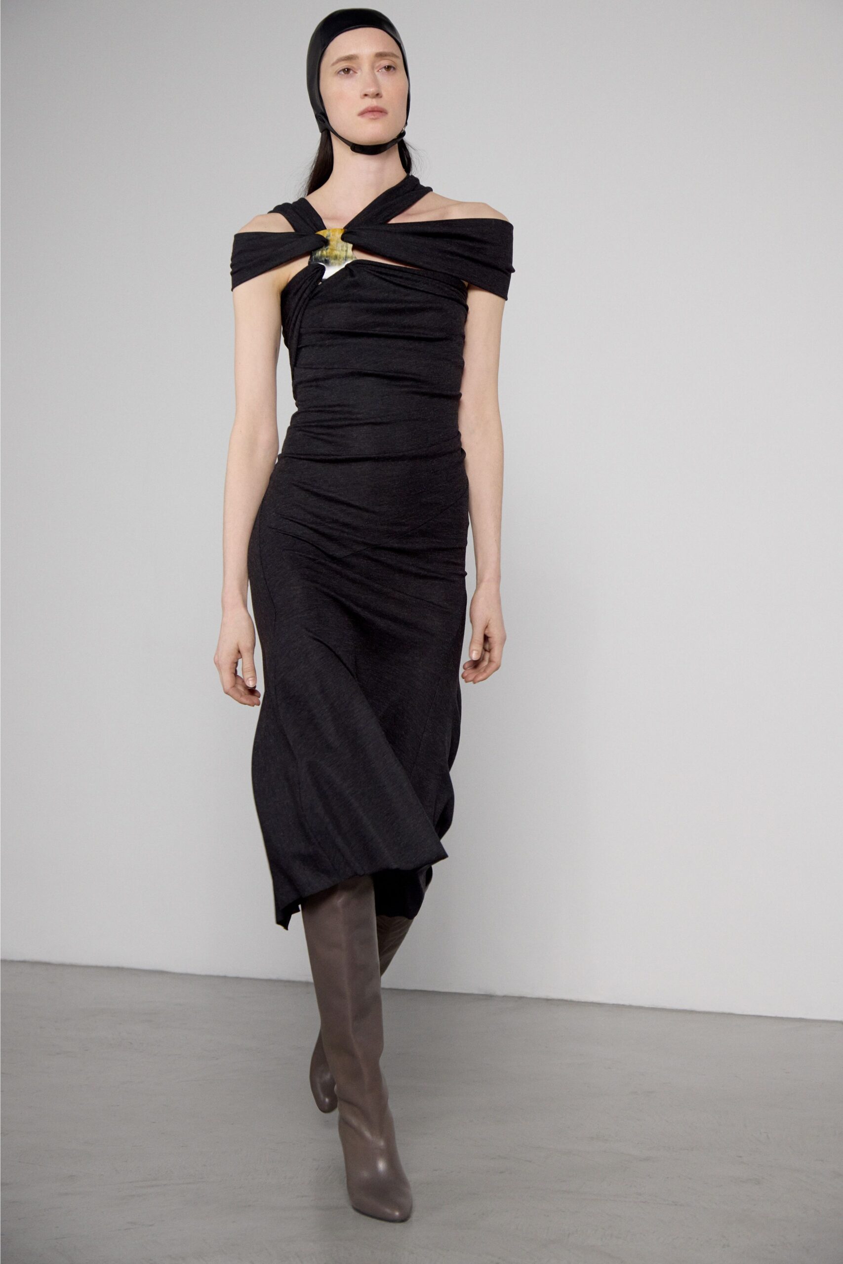 black fitted off-shoulder dress with brown boots