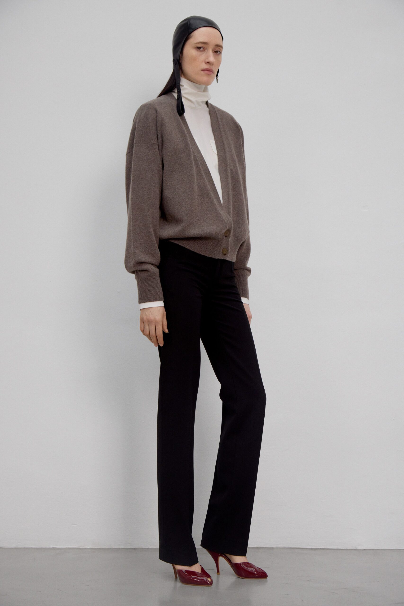 brown cardigan white turtleneck black pants red heels