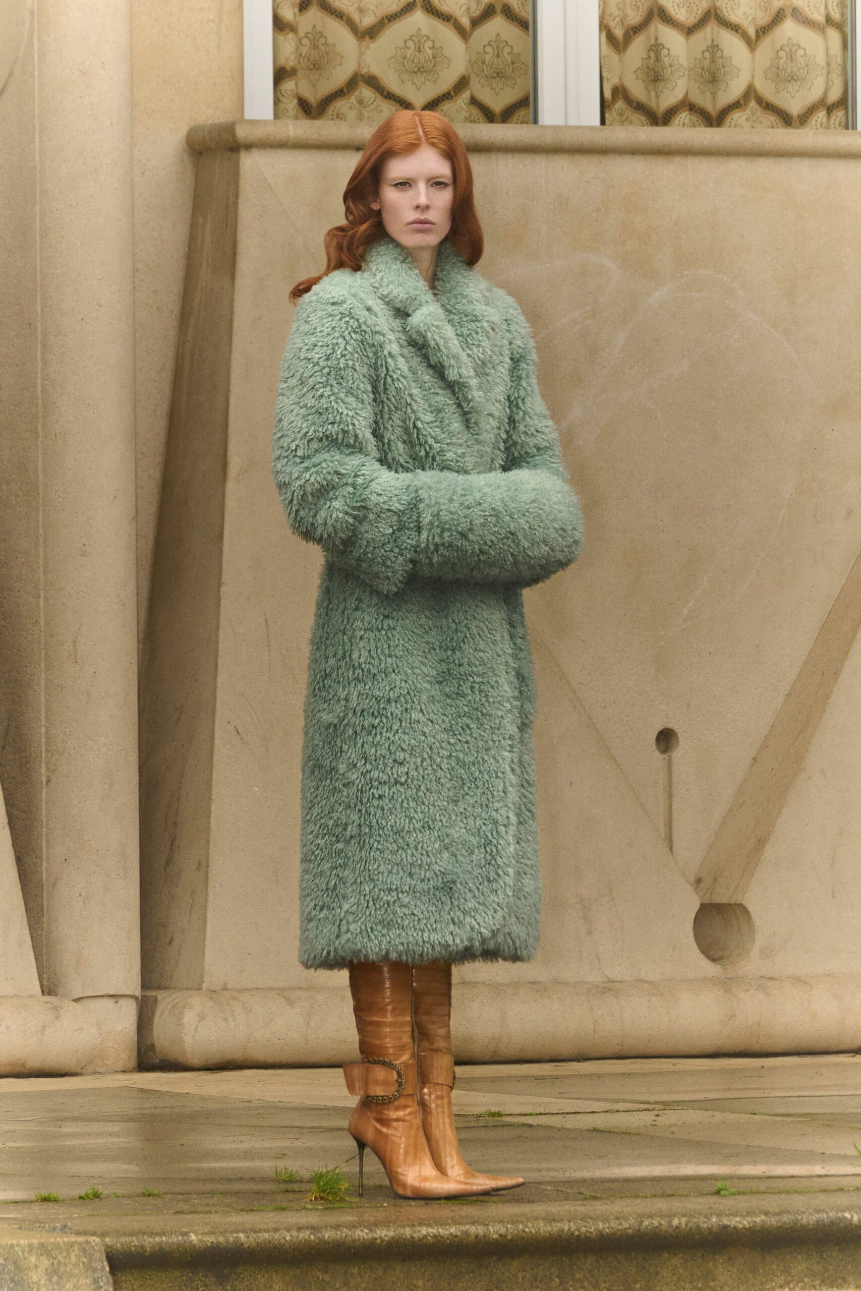 green faux-fur coat and brown leather boots