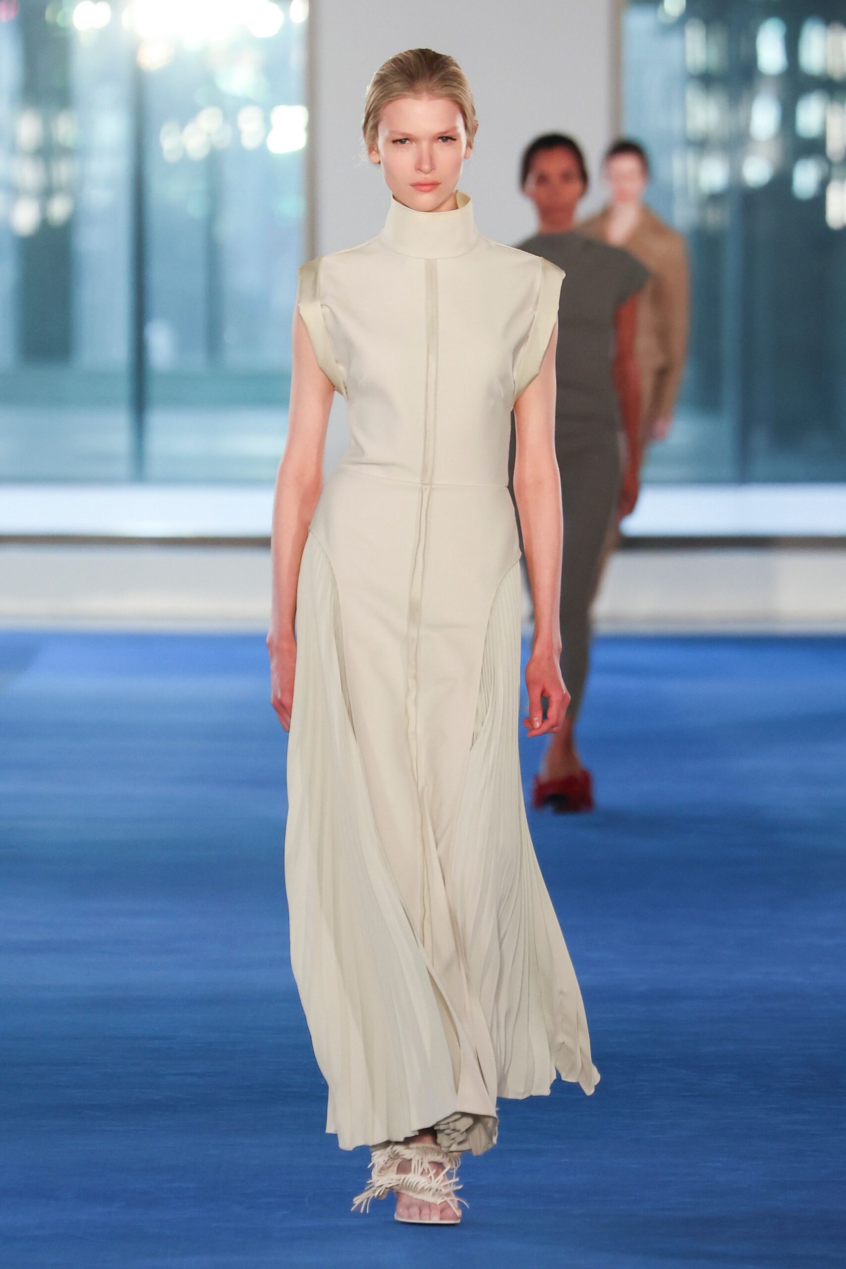 beige silk sleeveless high-neck fitted pleated flowing gown