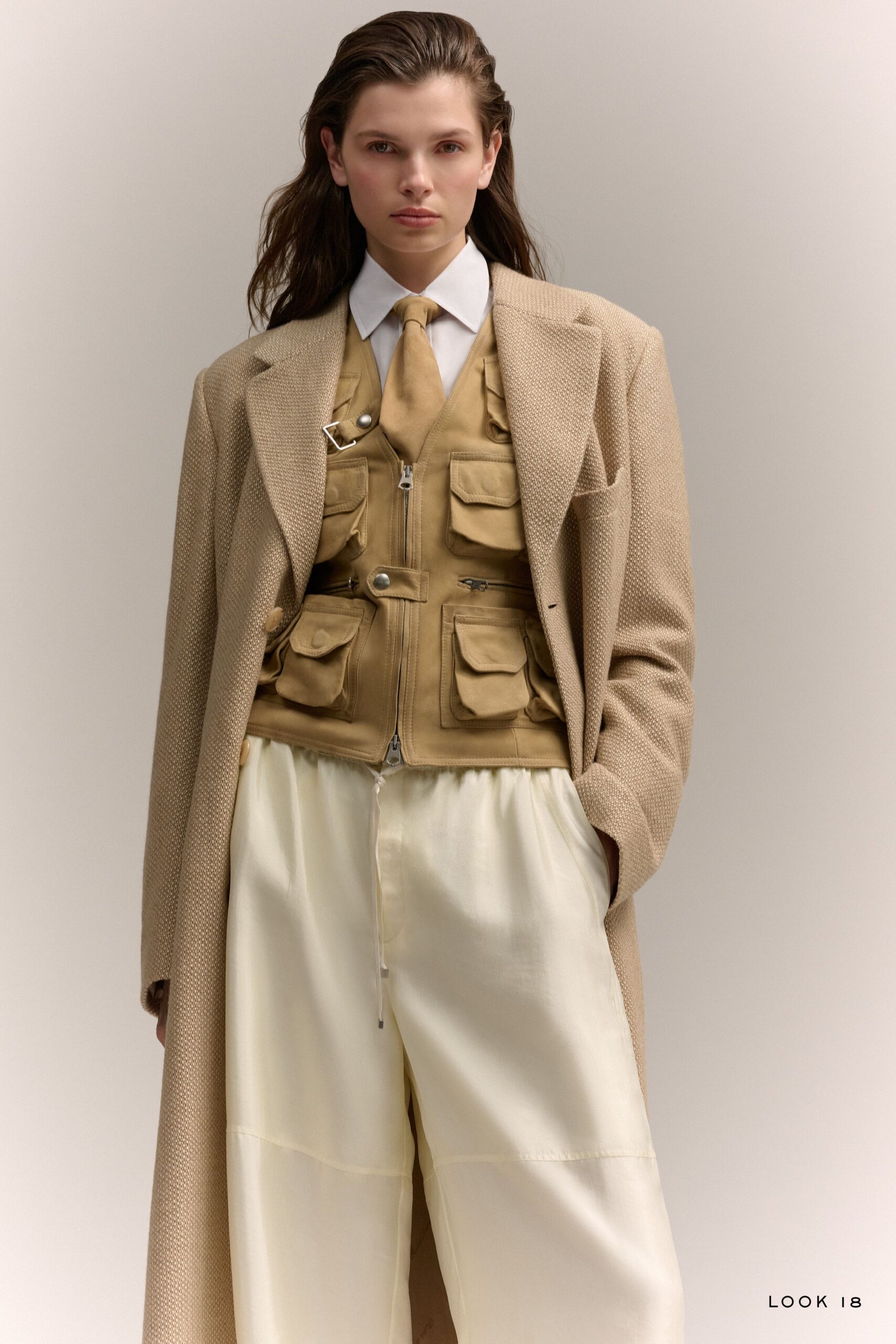 beige coat tan vest white shirt white pants